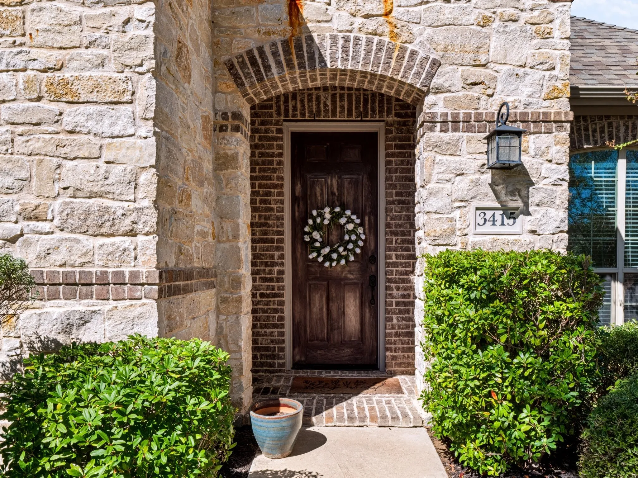 Stone and brick exterior with a wood-panel front door