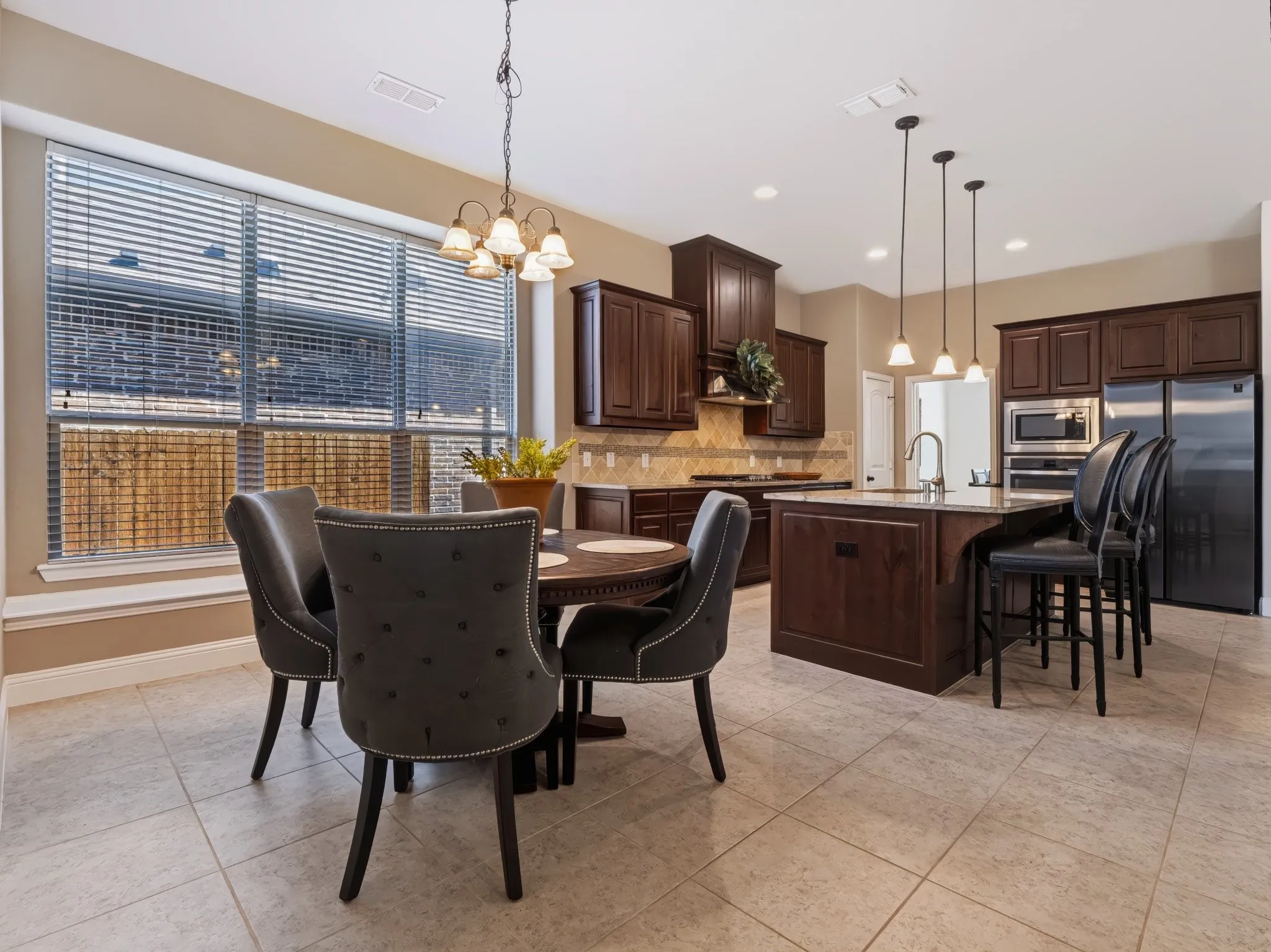 Gourmet kitchen featuring dark wood cabinetry, stainless steel appliances, and a large island with seating