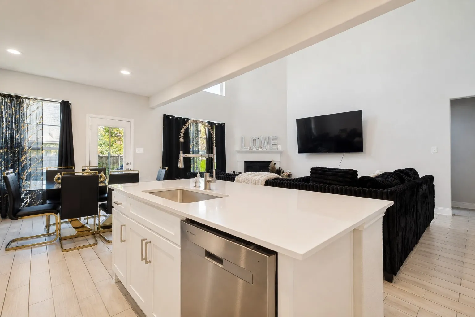 Kitchen island with an undermount sink, gooseneck faucet, and stainless steel dishwasher