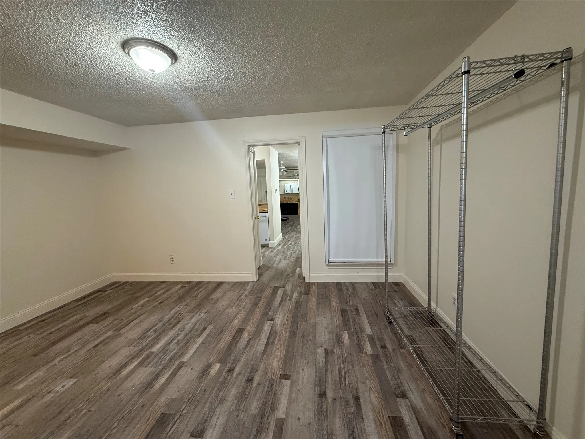 Bedroom with walk in closet and en suite bath. UBlockout electric remote controlled shade and luxury vinyl plank flooring.