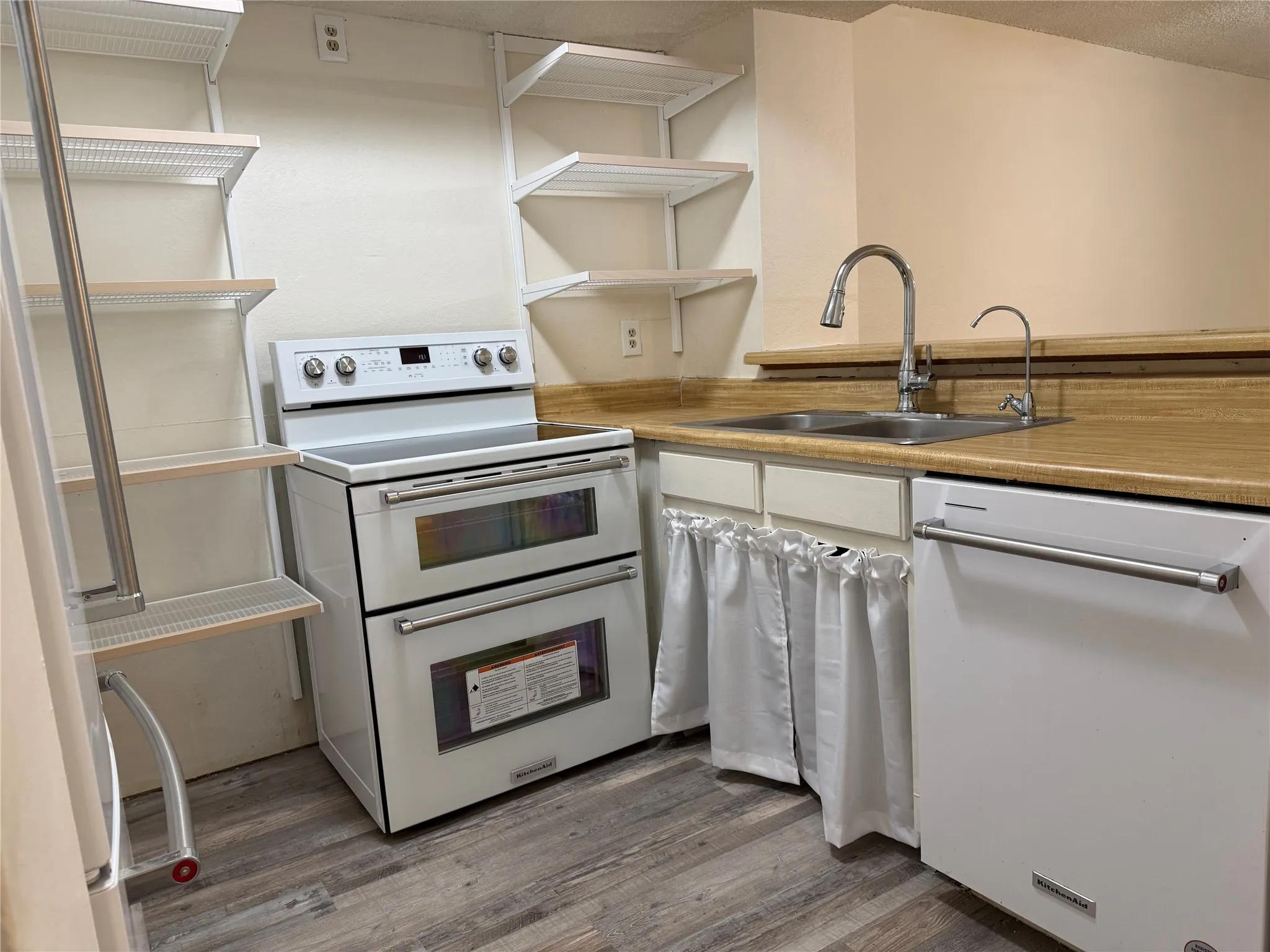 Kitchen with newer white KitchenAid appliances opens to Living Room with Bar seating
