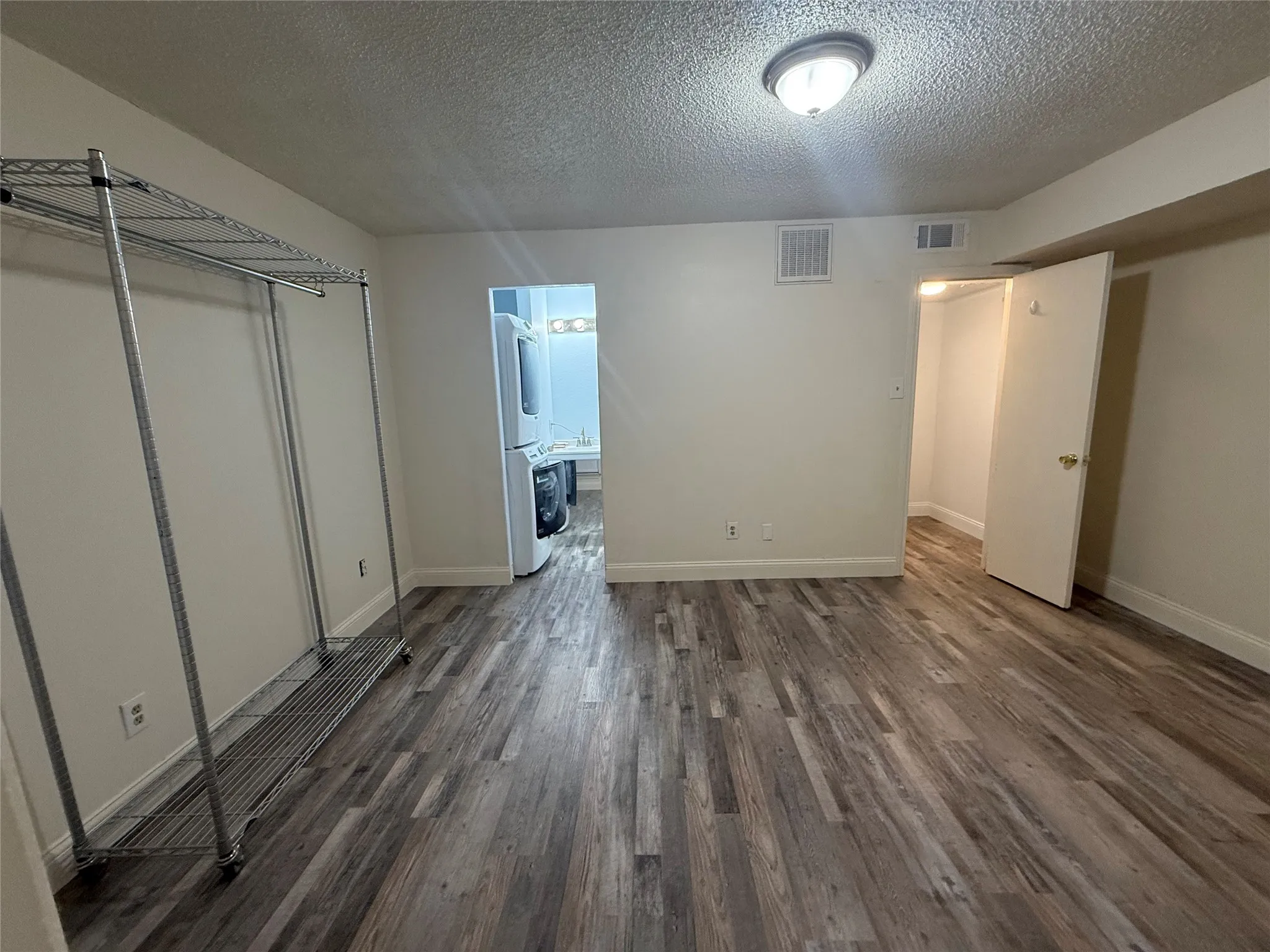 Bedroom with walk in closet and en suite bath. UBlockout electric remote controlled shade and luxury vinyl plank flooring.