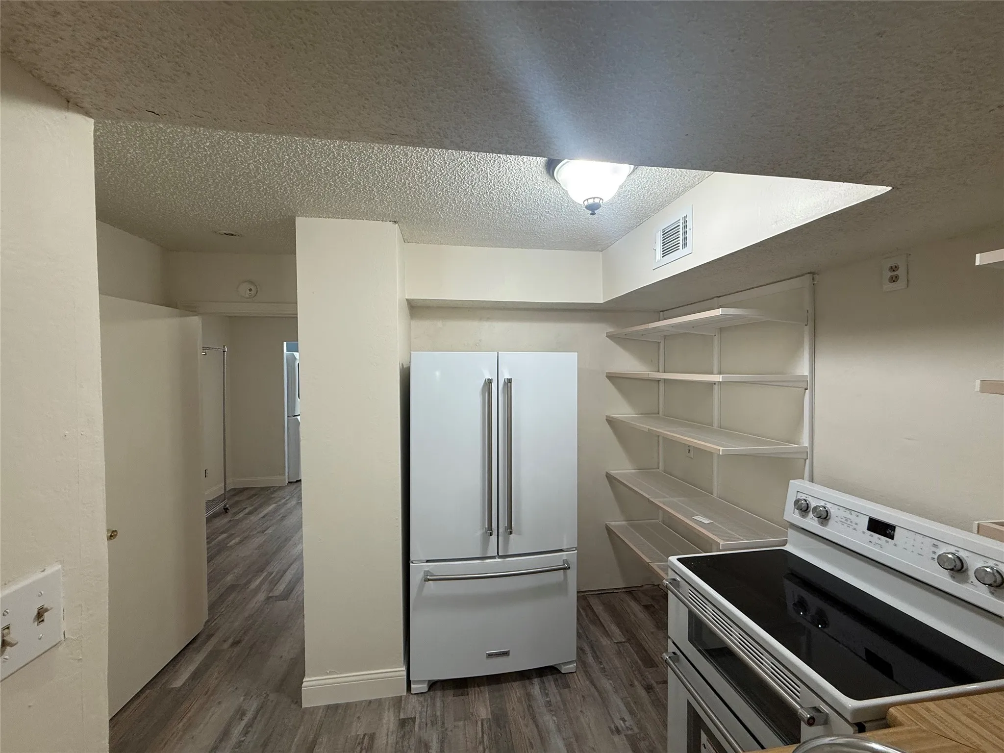 Kitchen with newer white KitchenAid appliances opens to Living Room with Bar seating