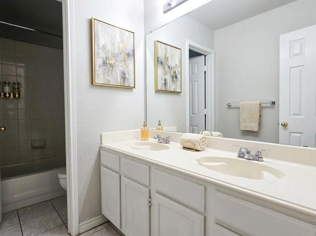 Dual vanity with integrated sinks, chrome faucets, and white cabinetry