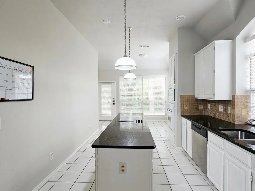 Kitchen with white cabinetry, dark countertops, a tiled backsplash, and recessed lighting