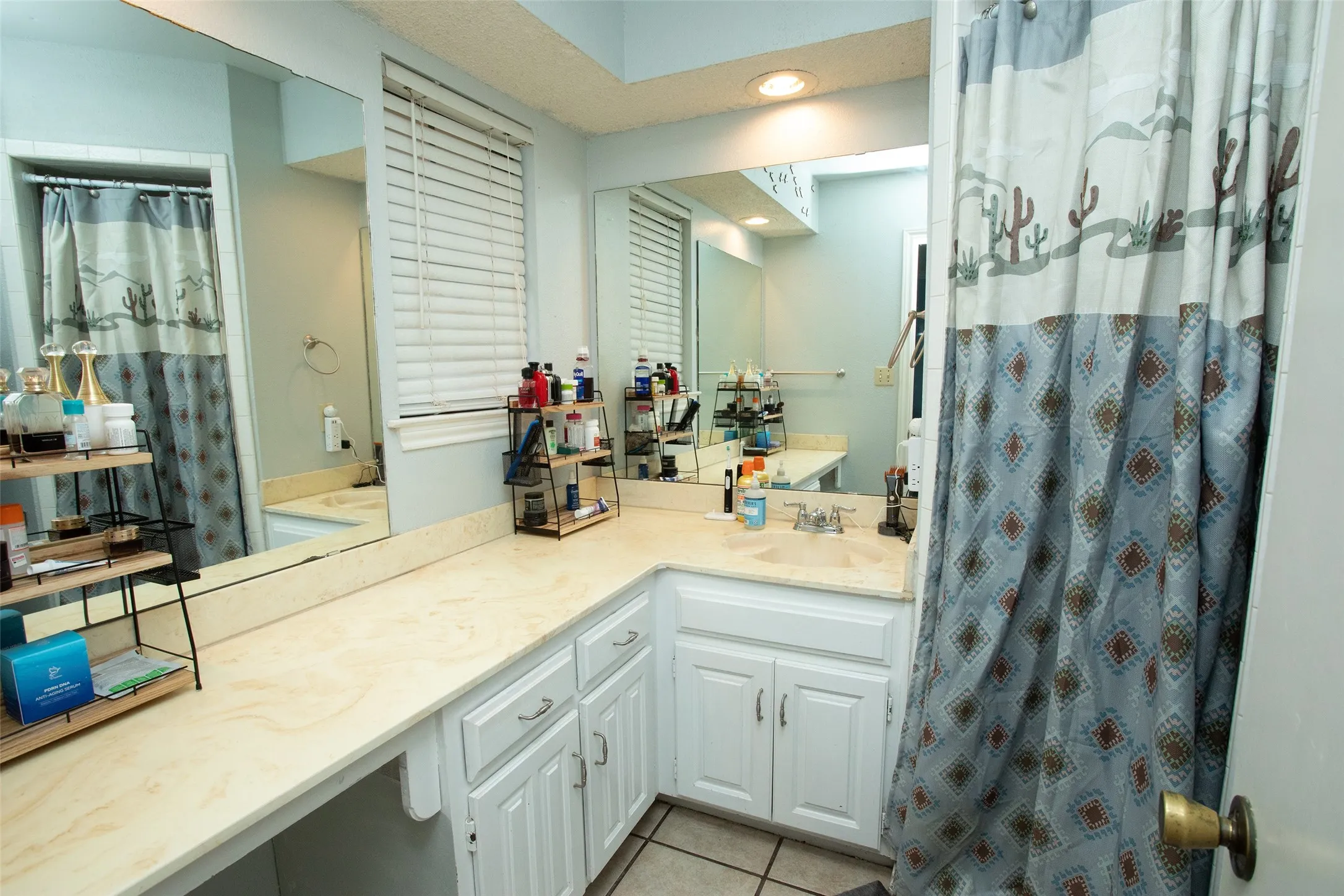 Long vanity with a built-in dressing table, white cabinetry, and light-colored countertops