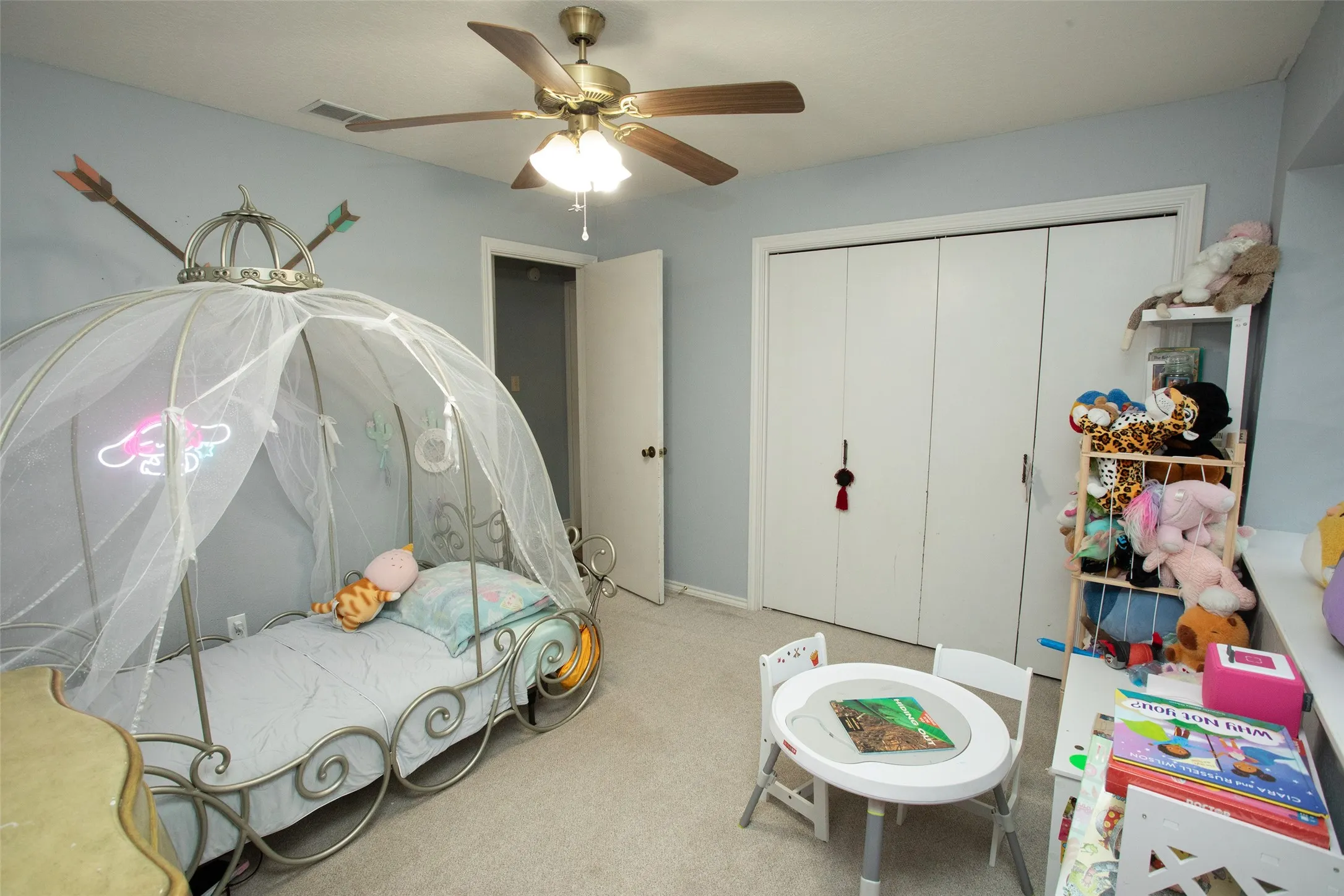 Ceiling fan with integrated lighting, light blue wall paint, and white bi-fold closet doors