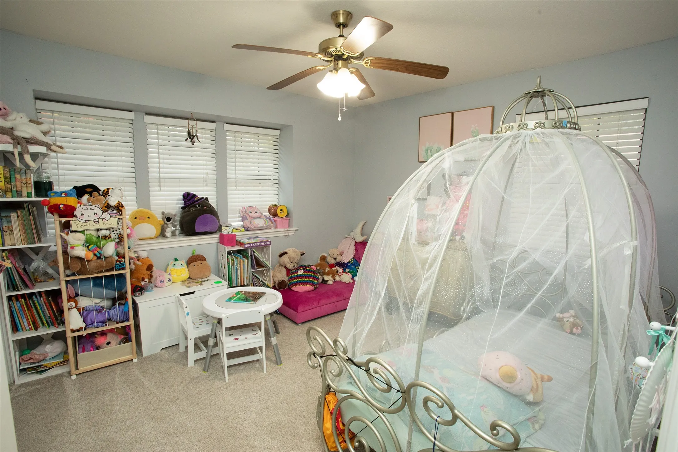 Recessed windows with blinds, ceiling fan with integrated lighting, and carpeted flooring