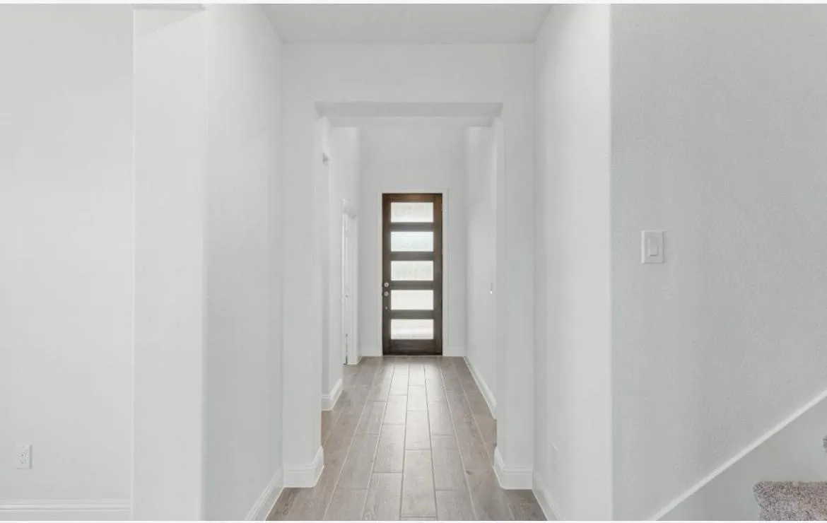 Hallway with light wood-type flooring and baseboards