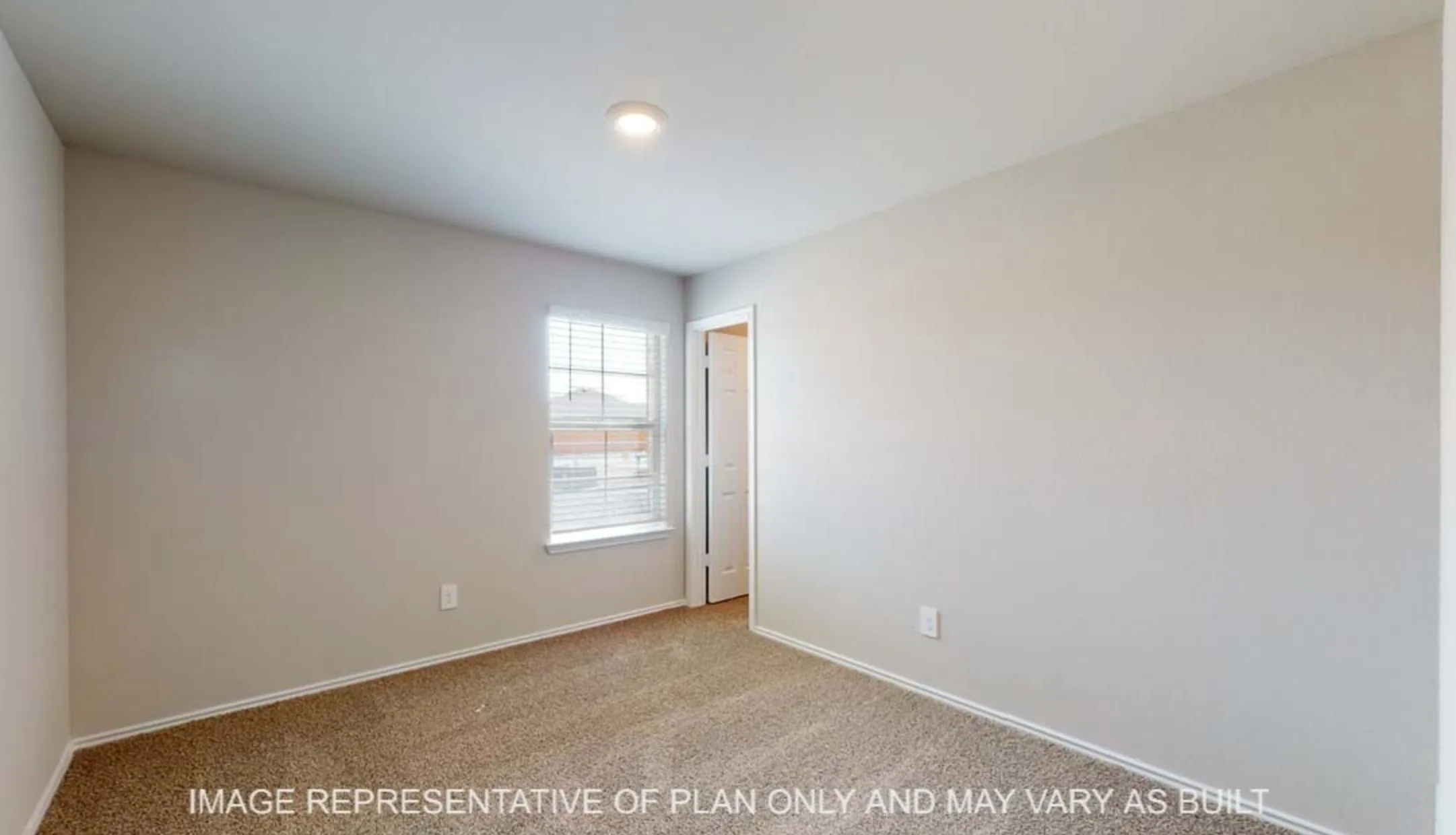 Neutral wall paint, plush carpeting, recessed ceiling light, and a window with blinds