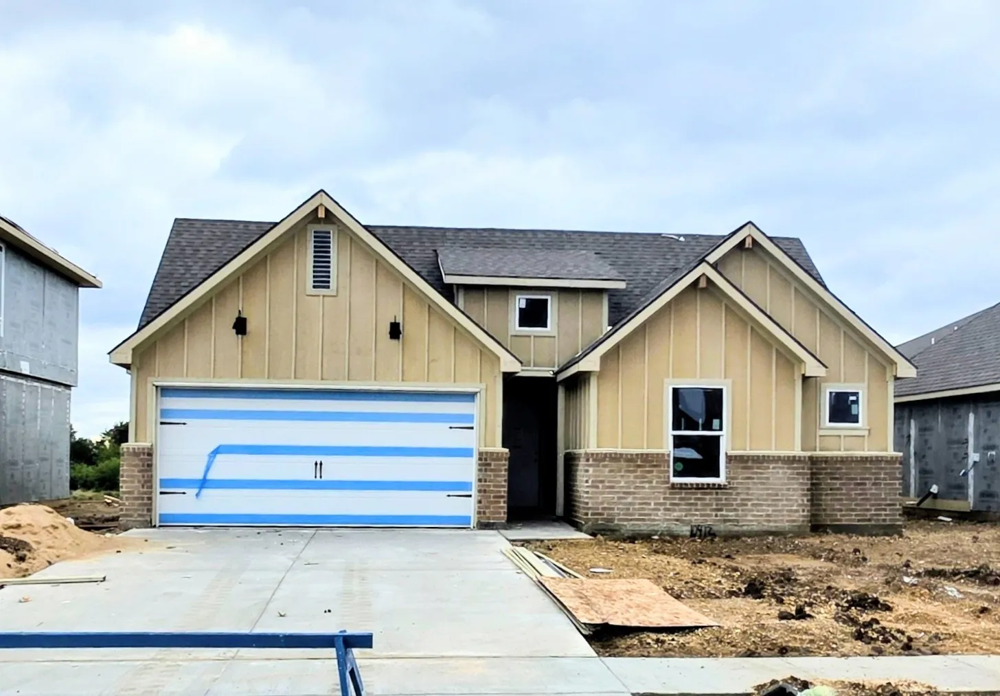 Board and batten siding with brick accents, dark-shingle roof, and a two-car​​‌​​​​‌​​‌‌​‌‌​​​‌‌​‌​‌​‌​​​‌​​ garage