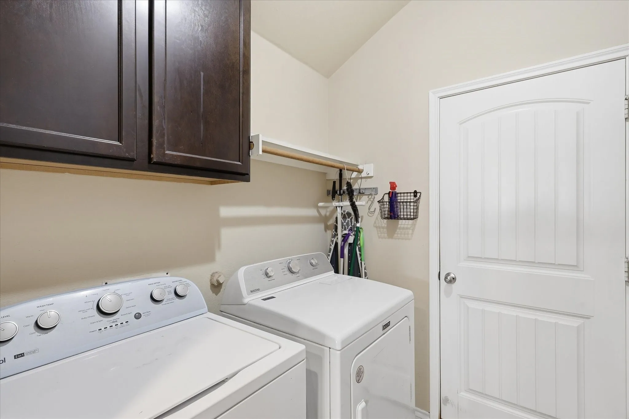 A usable laundry room space. Cabinets to keep items tucked away.  Hanging space and shelf. Door leads to 2 car garage.  Home has sprinkler system and control panel is in garage.