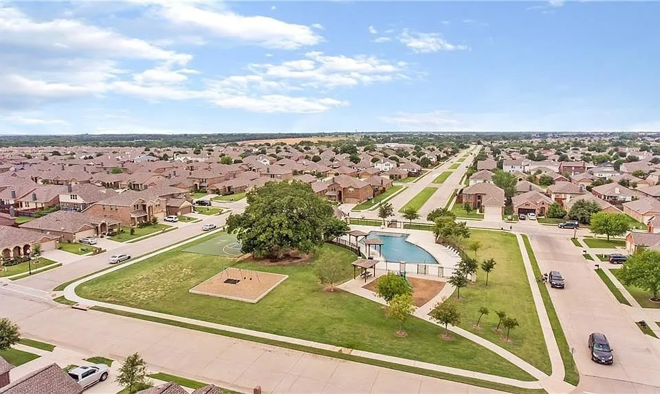 Community green space with a swimming pool, playground area, and mature trees