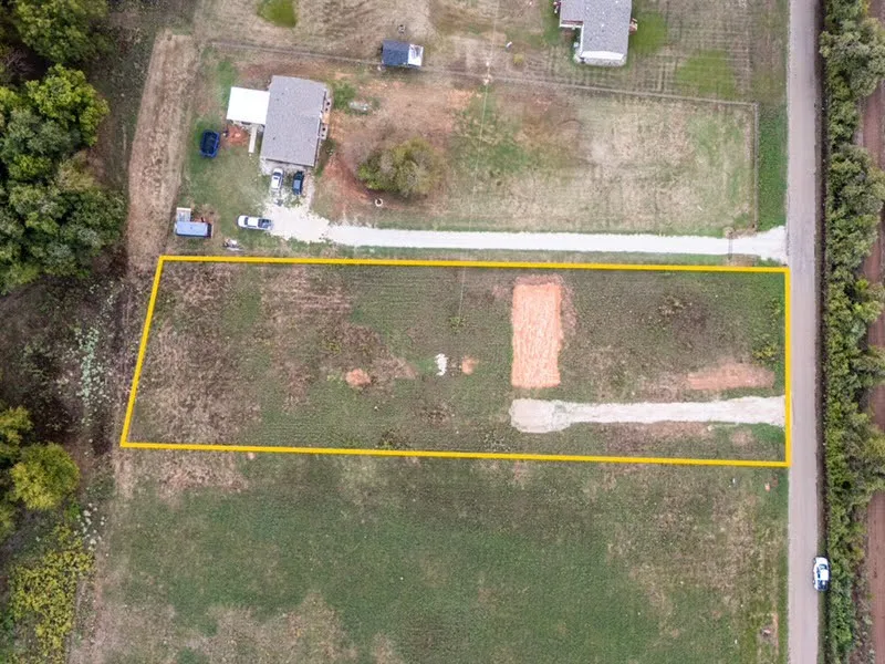 Expansive lot featuring a defined perimeter, partially cleared land, and direct road frontage