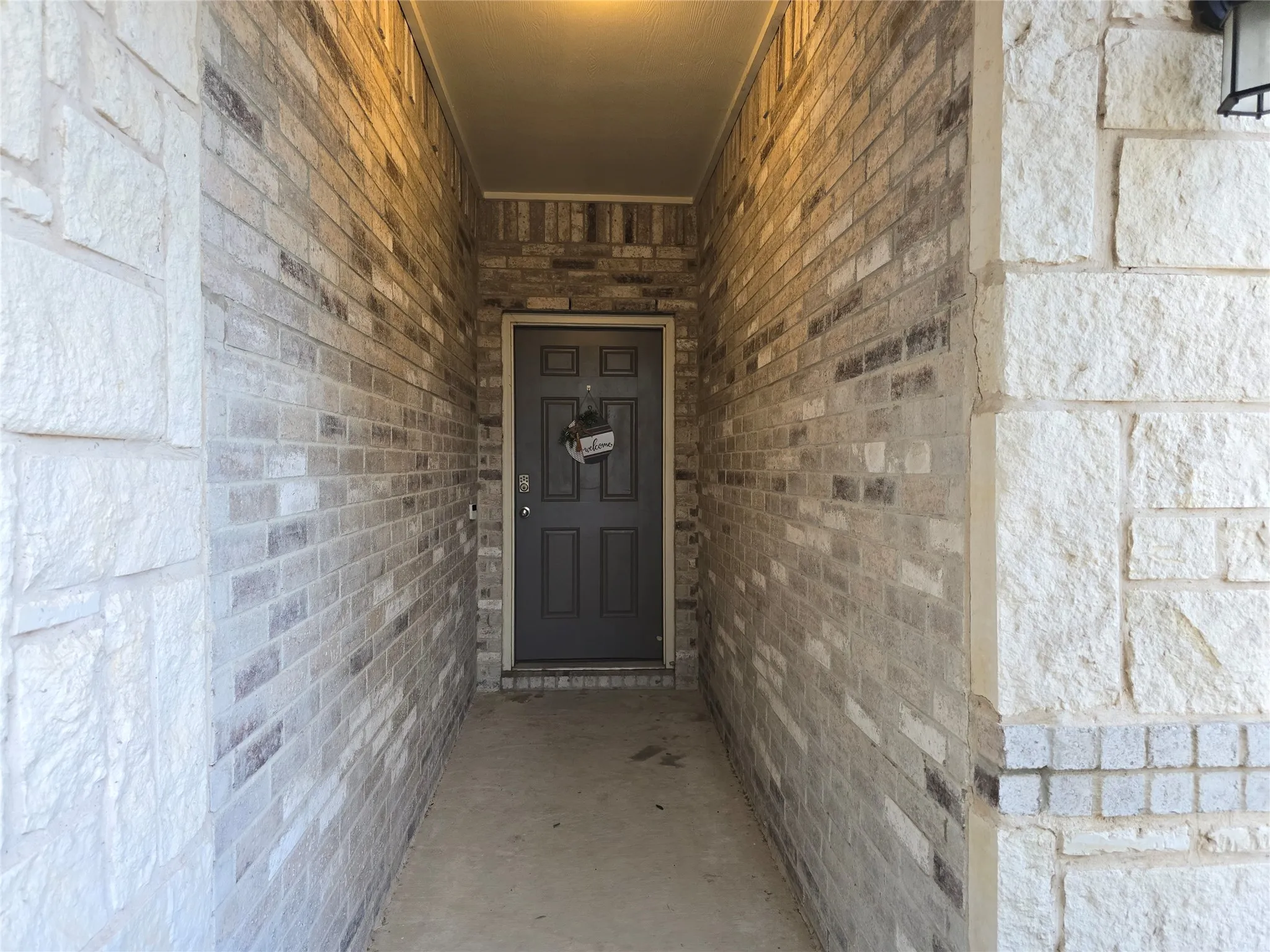 Recessed entry with multi-toned brick walls and natural stone detailing