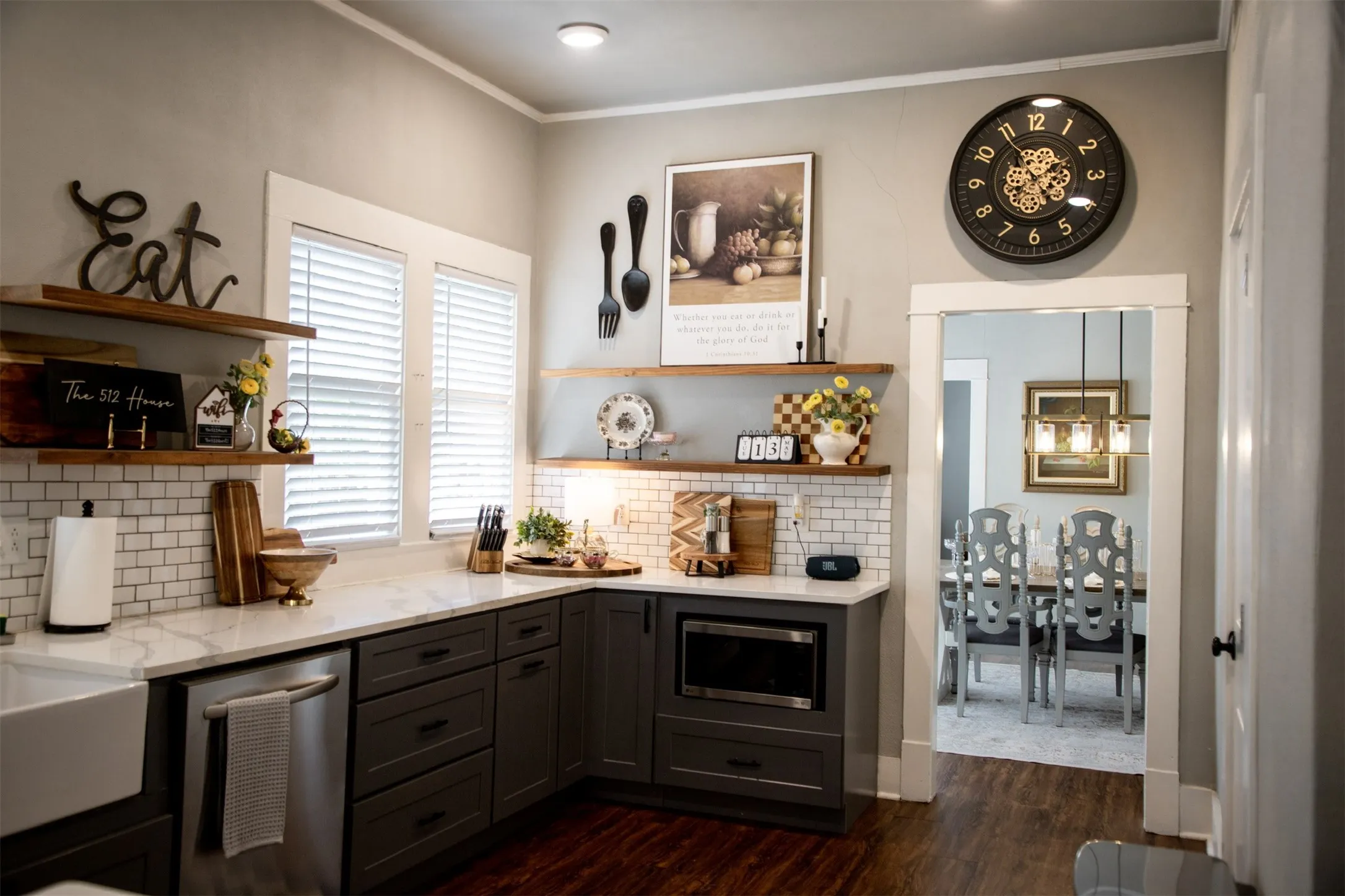 Kitchen featuring built-in stainless steel appliances, dark wood-finish cabinetry, white subway tile backsplash, and light-toned countertops
