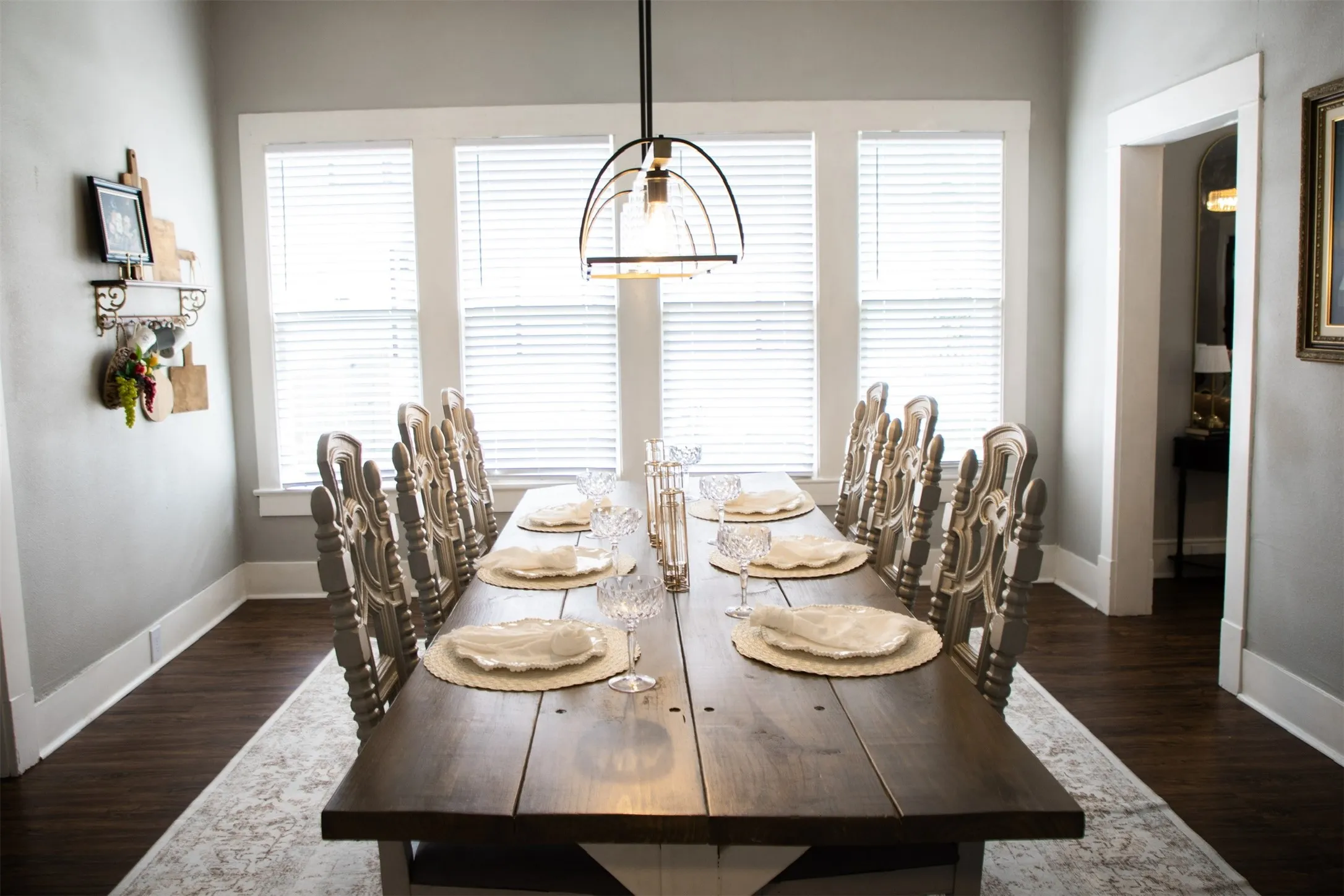 Spacious room with a dark wood-finish dining table and dark wood-finish flooring