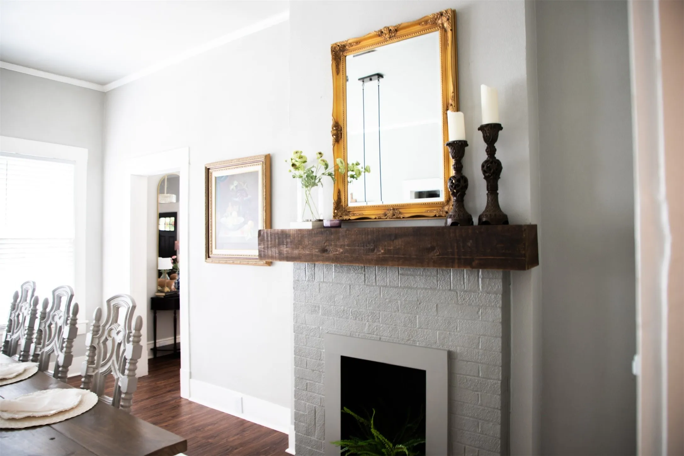 Painted brick fireplace with a wood-finish mantel and a framed mirror