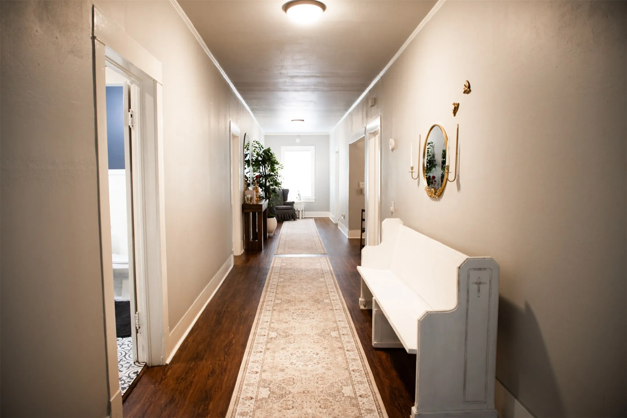 Long corridor featuring wood-finish flooring, light-toned walls, and a recessed ceiling light