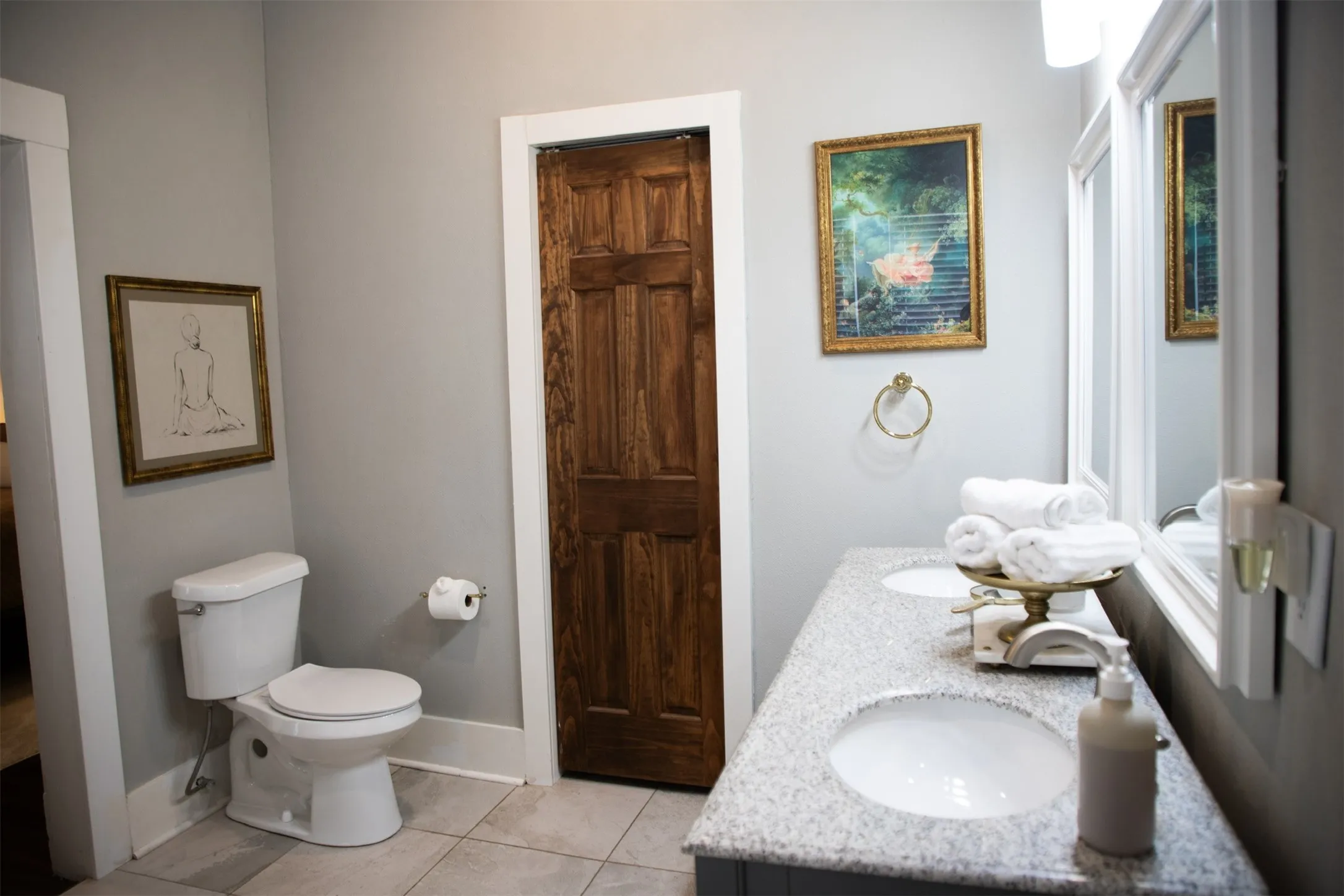 Dual vanity with undermount sinks, stone-finish countertop, and framed mirrors