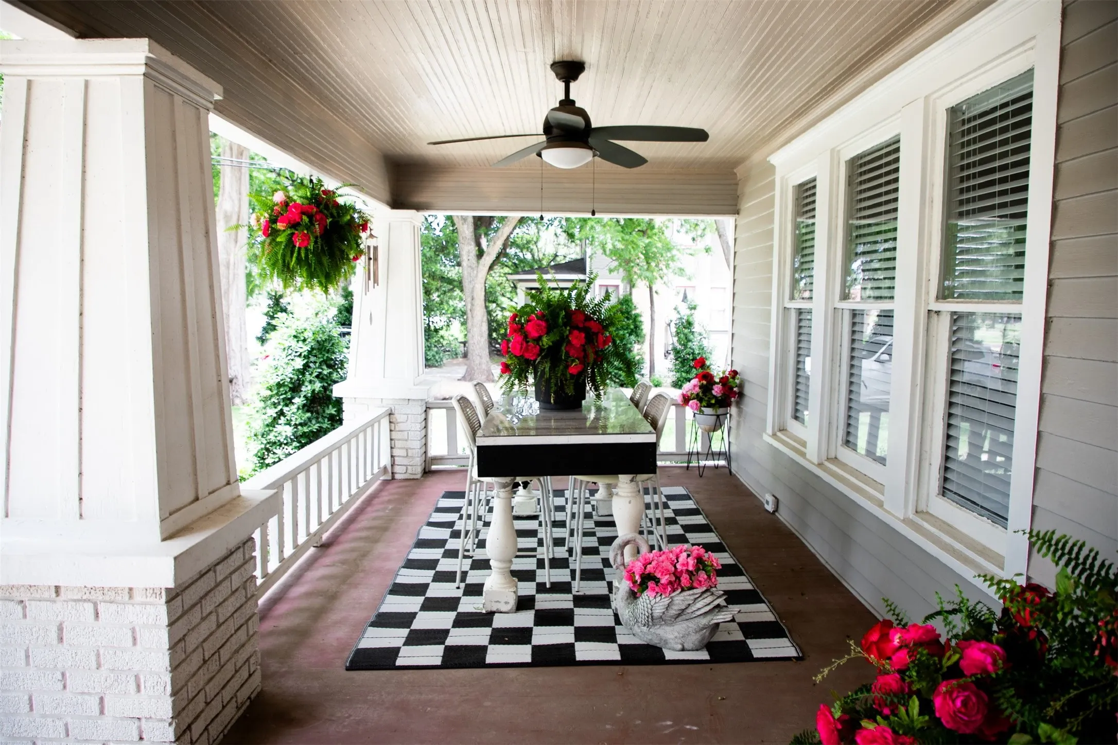 Expansive porch featuring a paneled ceiling, white painted brick, white railing, and multiple windows