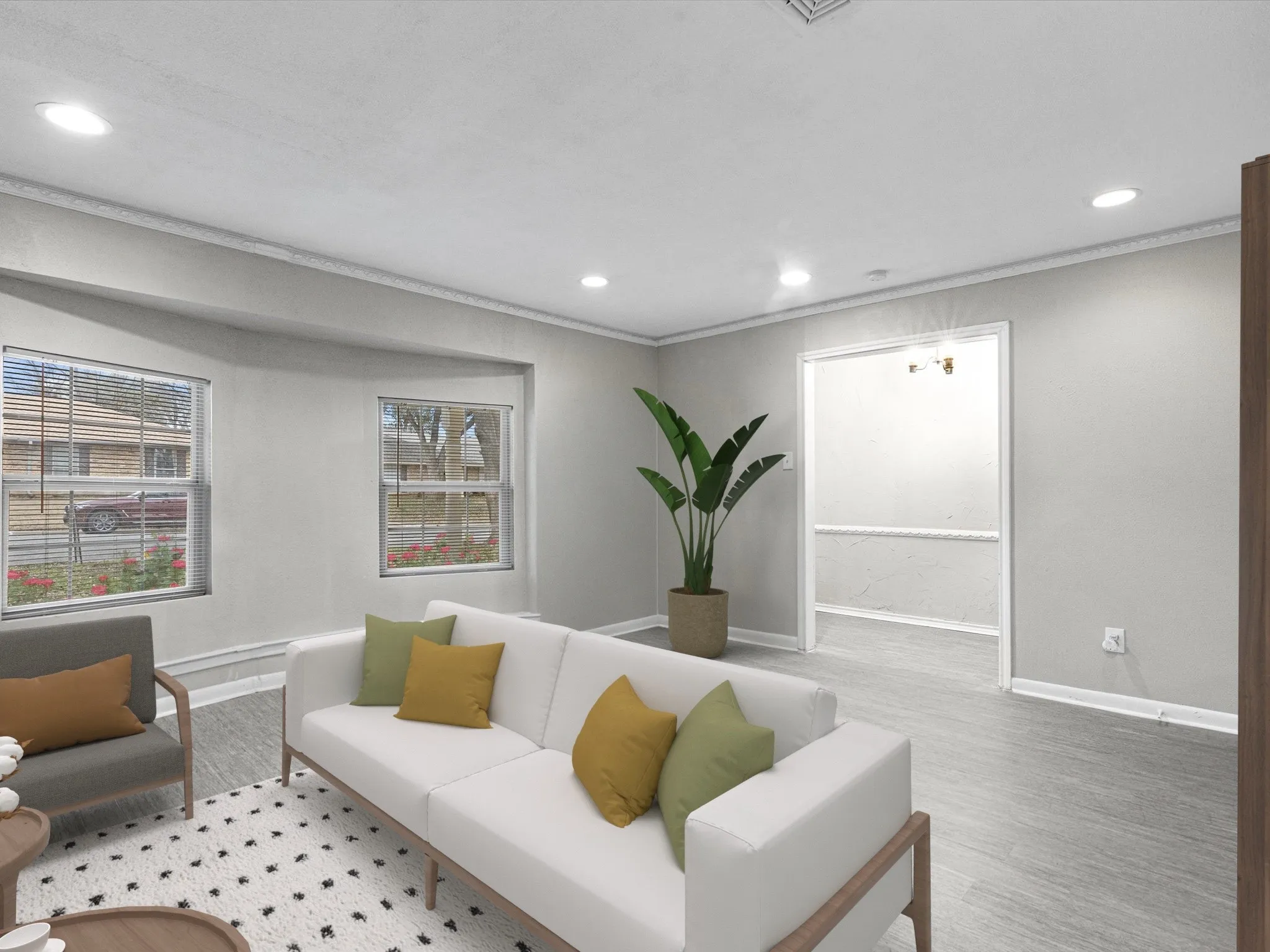 Recessed lighting illuminates wood-finish flooring and a neutral color palette