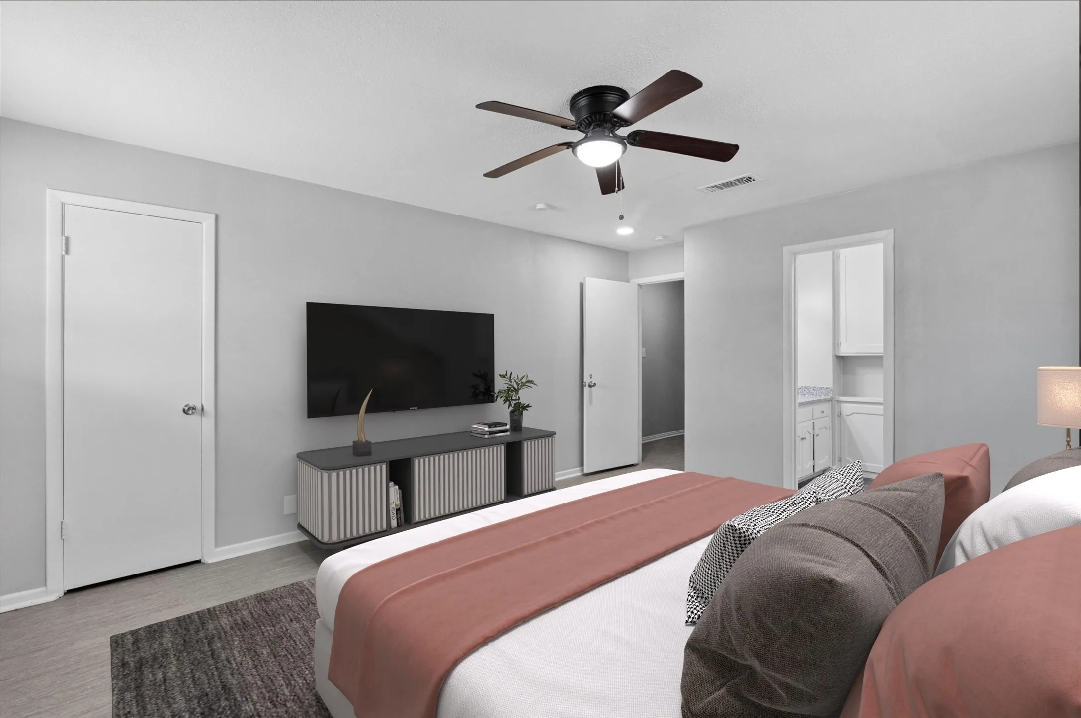 Spacious room with light gray walls, wood-finish flooring, and a ceiling fan with integrated lighting