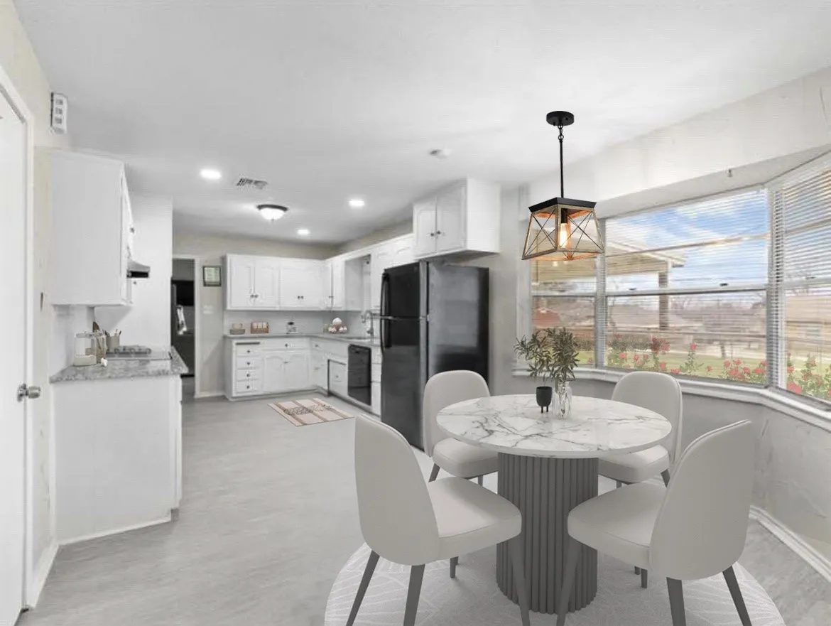 Spacious kitchen featuring white cabinetry, light-toned flooring, and a bay window