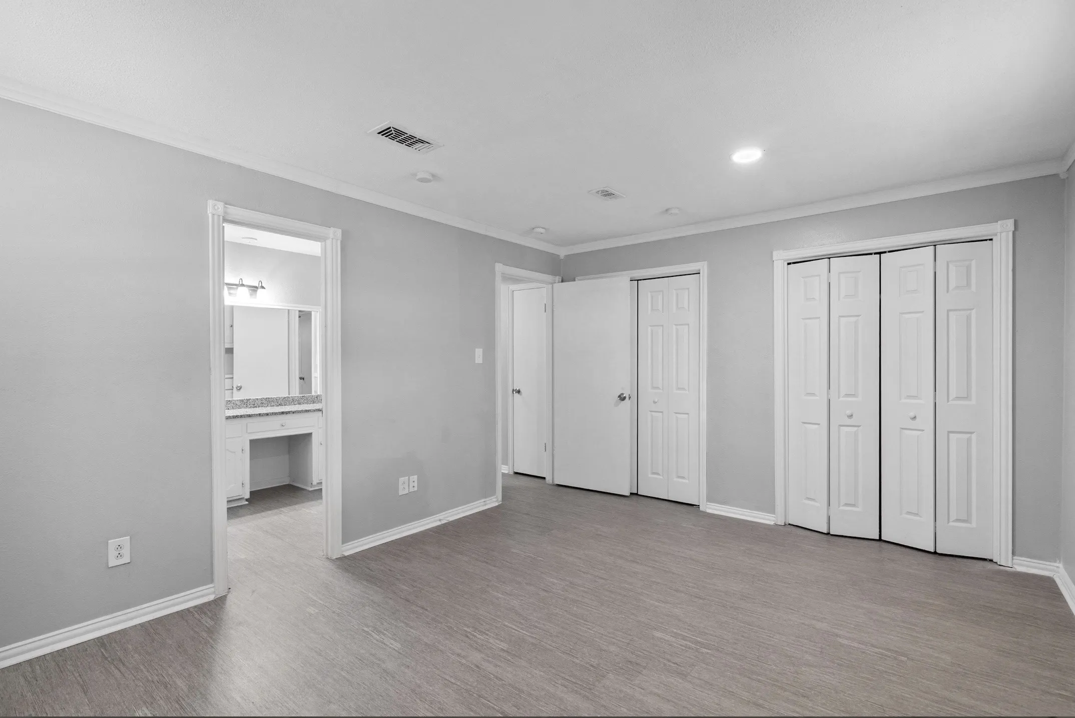 Spacious room featuring wood-finish flooring and light gray walls