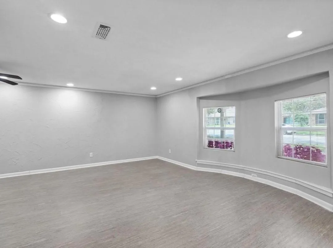 Recessed lighting, crown molding, a bay window with two windows, and wood-finish flooring