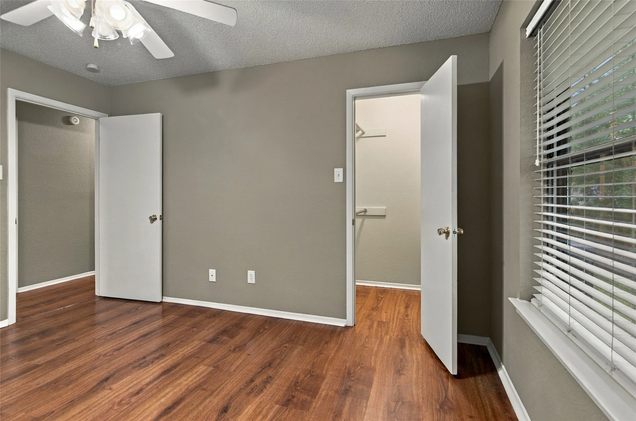 LVP flooring, a ceiling fan with light fixture, and a window with blinds