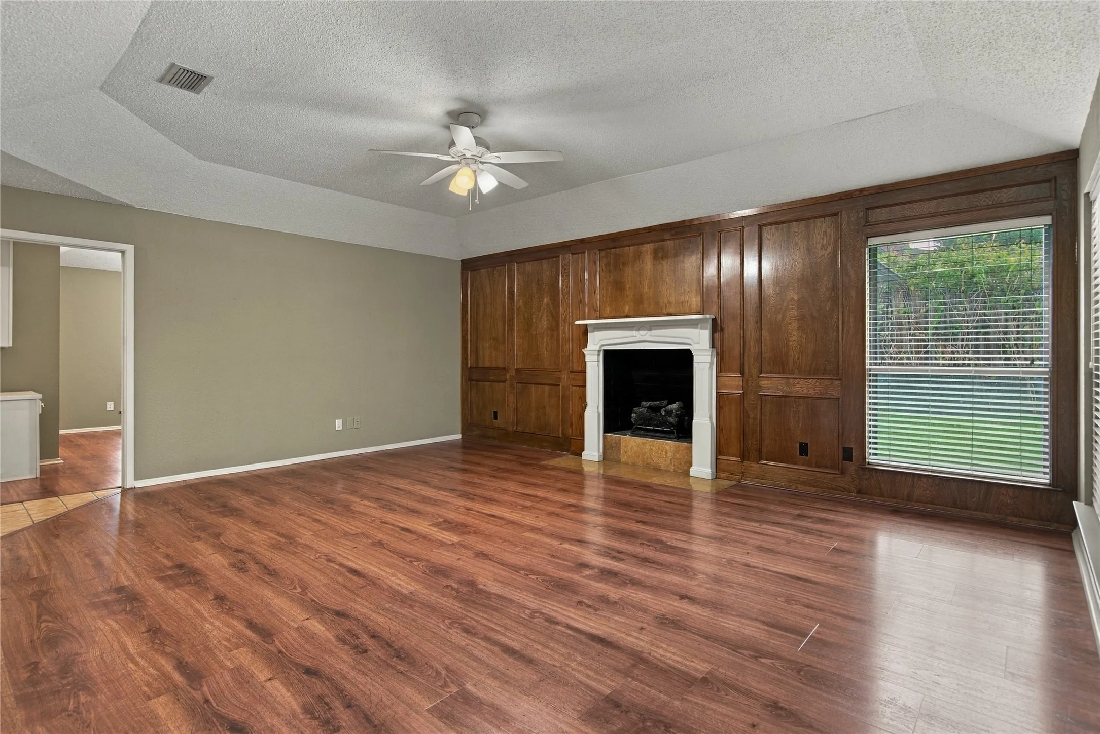 Spacious living area features a fireplace with gas logs