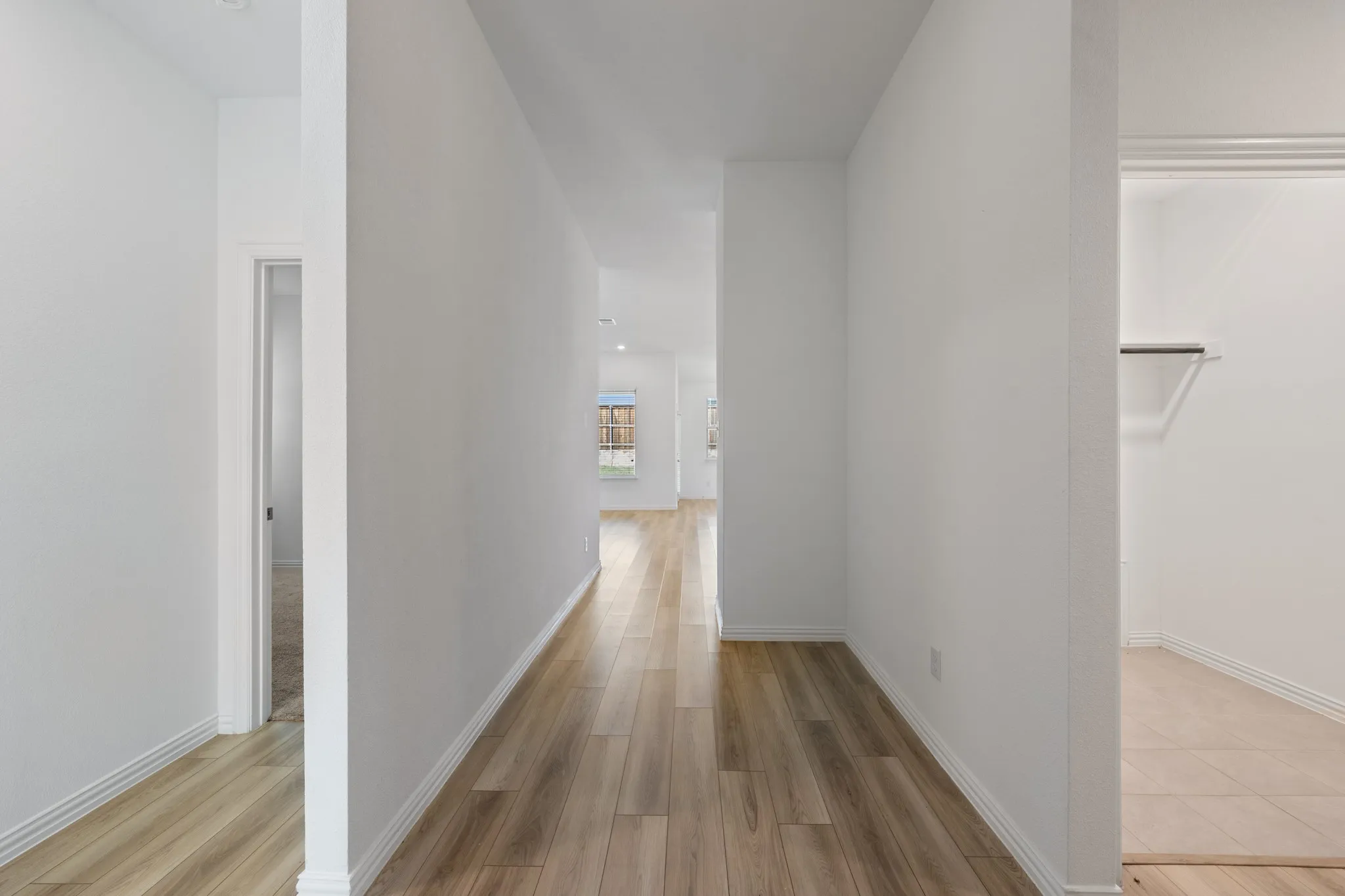 Hallway featuring wood-finish flooring, white walls, and recessed lighting
