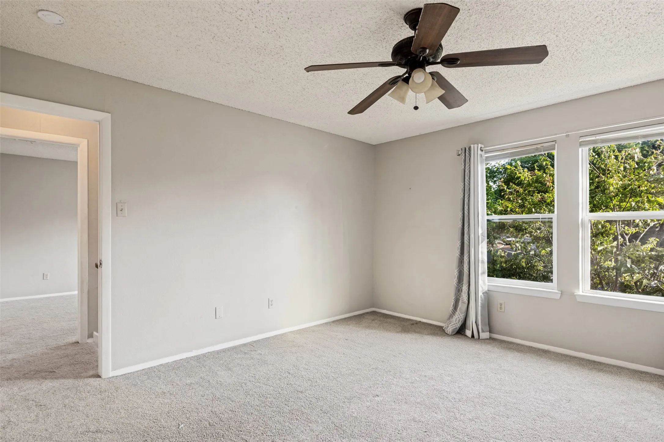 Soft gray wall paint, recessed lighting, ceiling fan with light fixture, carpeted flooring, and two windows