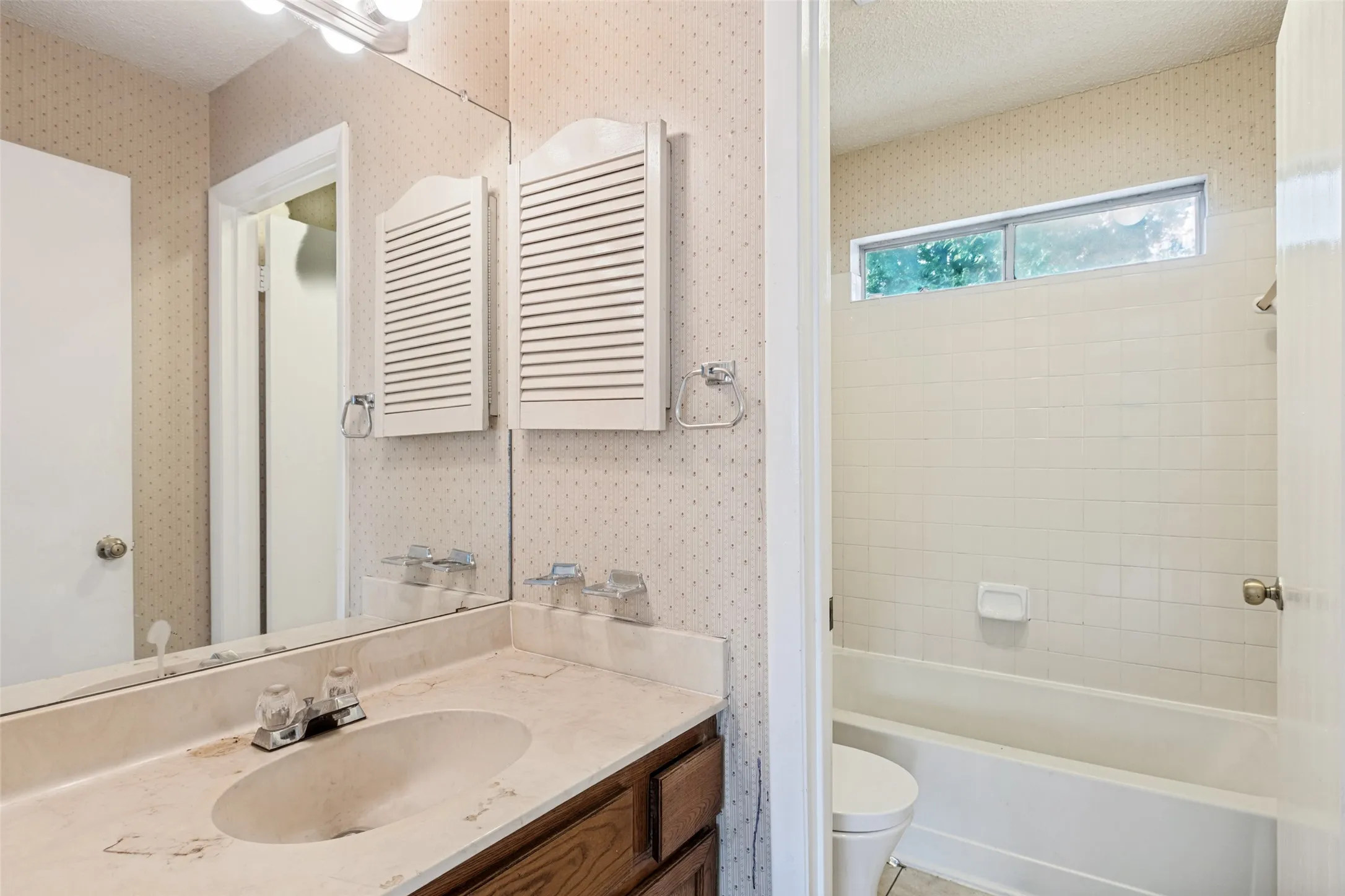 Bathroom vanity with an integrated sink, wood-finish cabinetry, and a vanity mirror