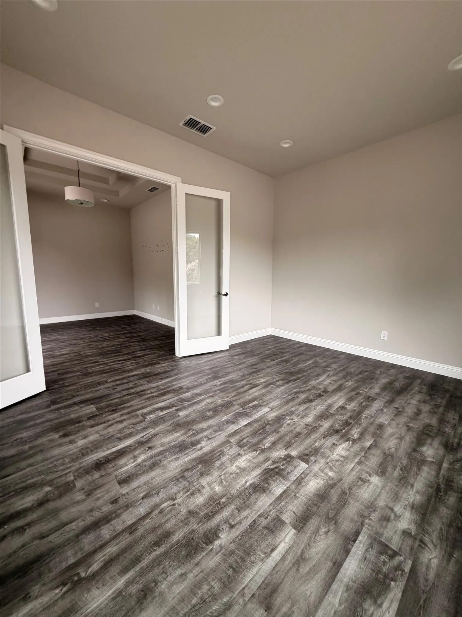 Wood-finish flooring, recessed lighting, and a white trim package