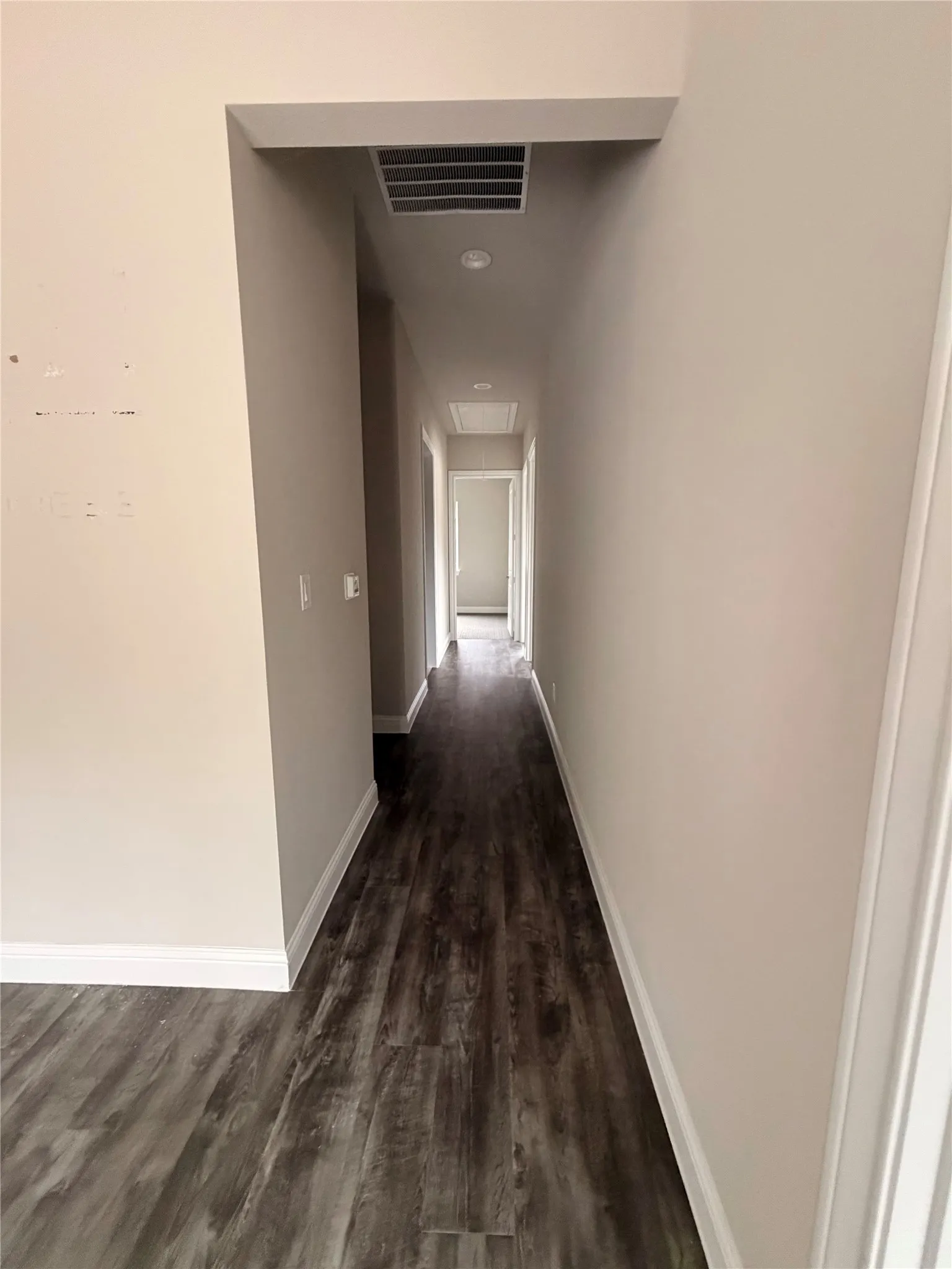 Hallway with wood-finish flooring, light-toned walls, recessed lighting, and white trim