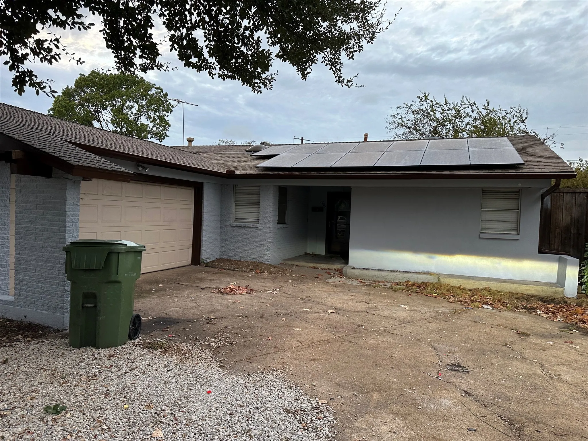 Solar panel array, single-car garage, and partial wood fencing