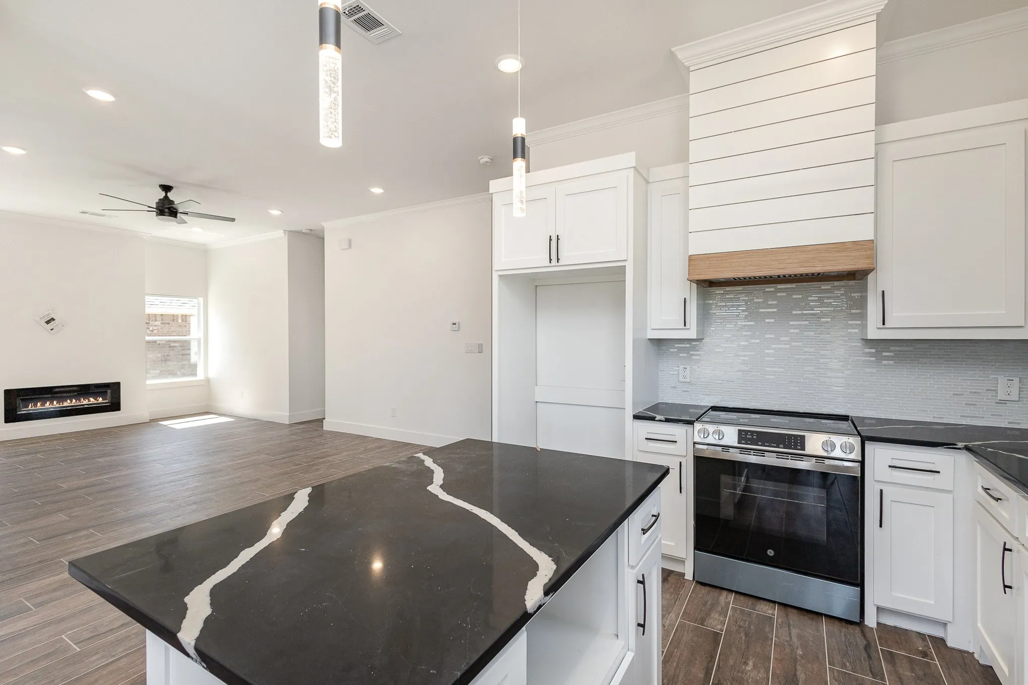 Gorgeous countertop, vent hood, and lighting.