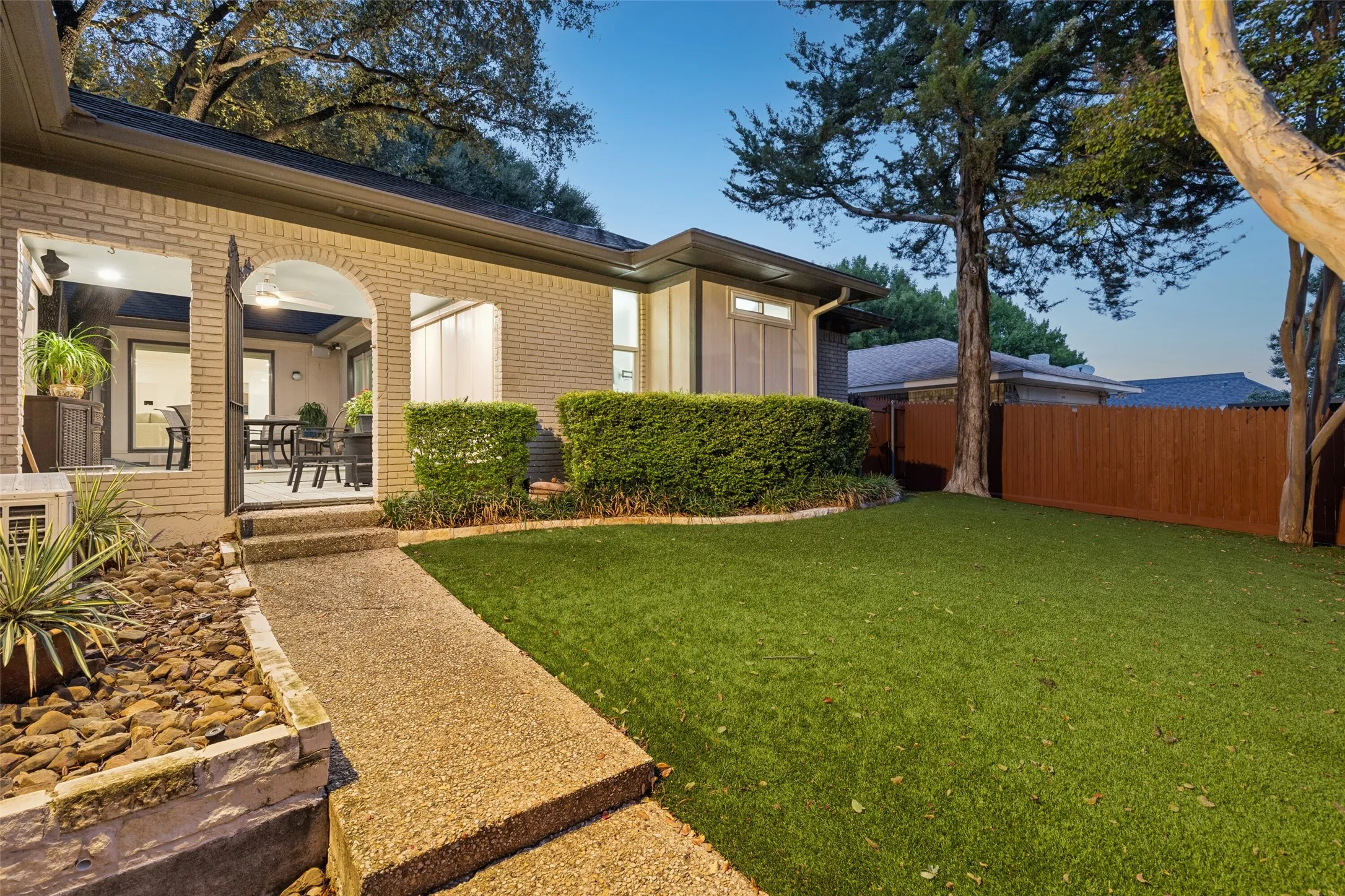 Private Backyard Retreat — A low-maintenance turf lawn, mature trees, privacy fencing, and easy access to the covered patio create an outdoor space designed for relaxing, entertaining, and everyday enjoyment.