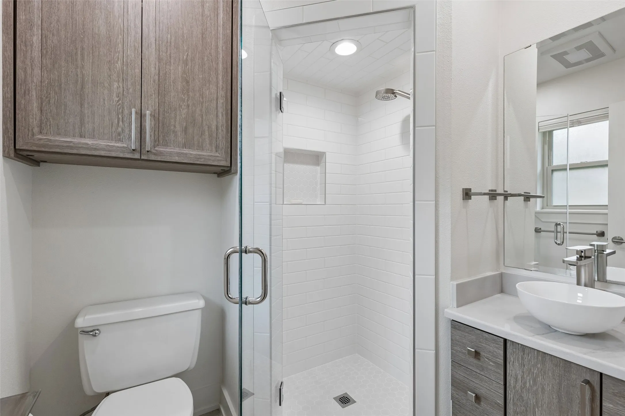 Updated Bath with Frameless Shower — A glass-enclosed shower, clean tilework, updated vanity, and streamlined finishes give this bath a fresh, functional feel.