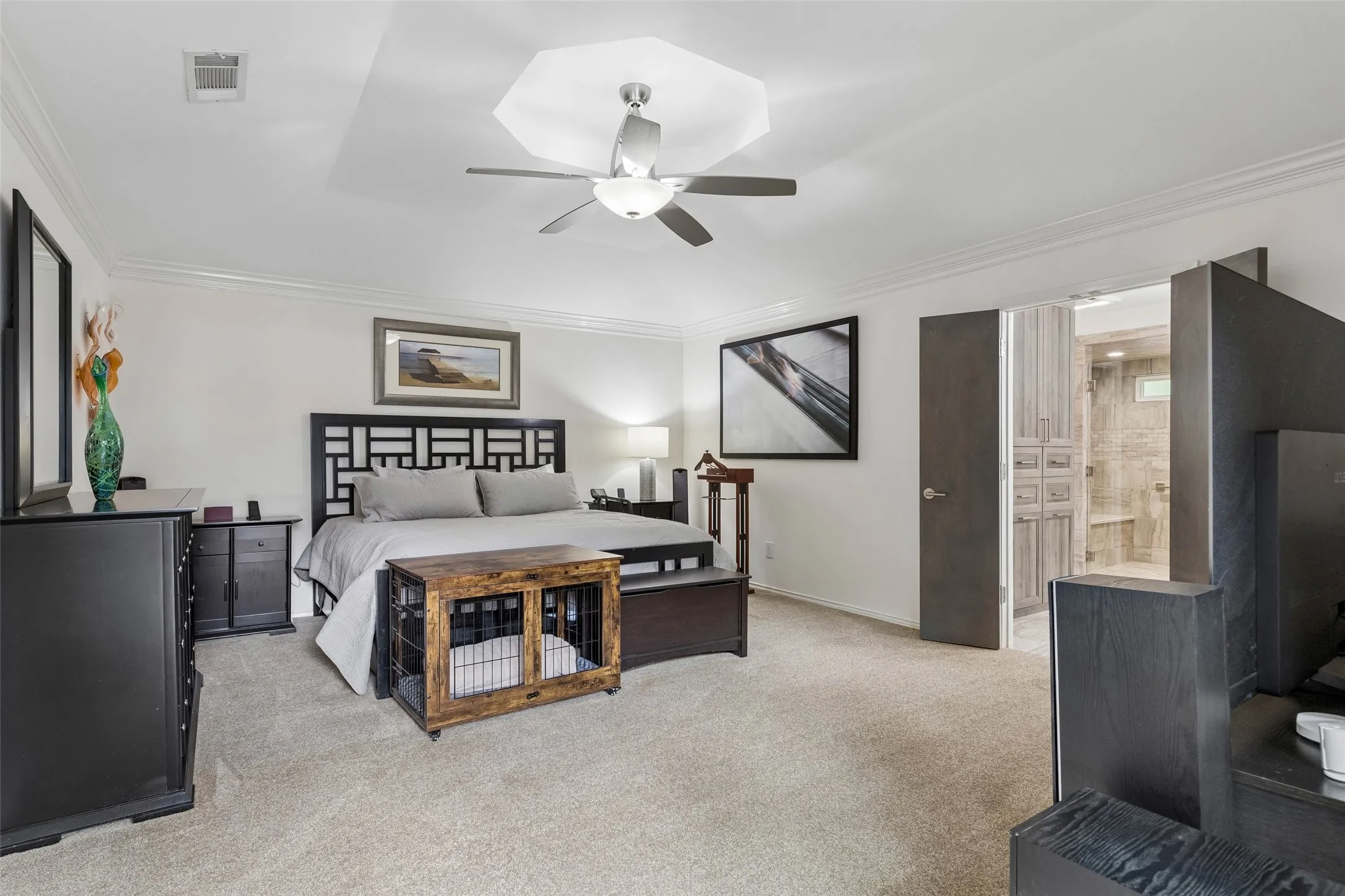 Spacious Primary Retreat — The primary bedroom offers a generous footprint, soft carpeting, crown molding, and direct access to the remodeled bath for a comfortable private retreat.