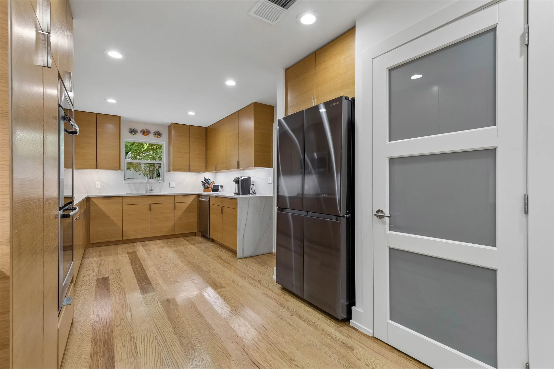 A Kitchen Designed for Daily Efficiency — Tall cabinetry and a well-planned work zone maximize storage while keeping the refrigerator, prep areas, and adjoining dining space within easy reach.