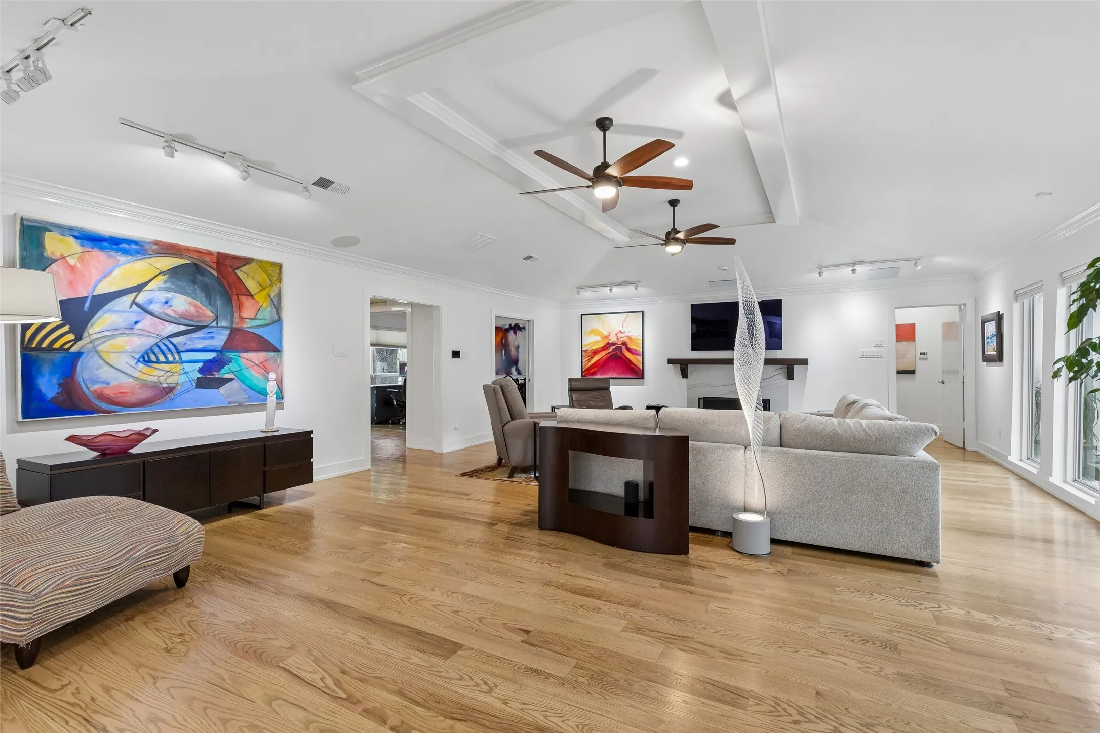 A Living Room Designed to Gather — An expansive footprint, hardwood flooring, and a central fireplace create a natural gathering space with plenty of flexibility for conversation, media, and relaxation.