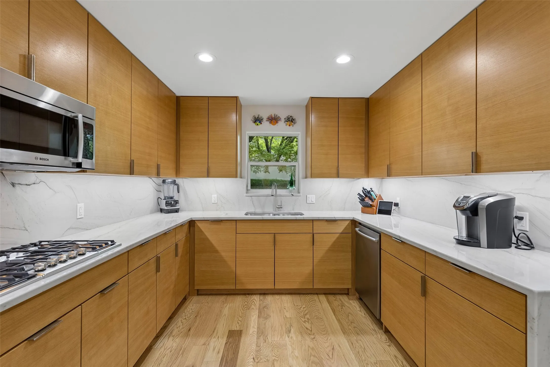 Cook-Friendly Layout with Gas Cooking — The gas cooktop sits within a broad stretch of counter space, surrounded by abundant cabinetry that keeps prep tools, cookware, and everyday essentials close at hand.