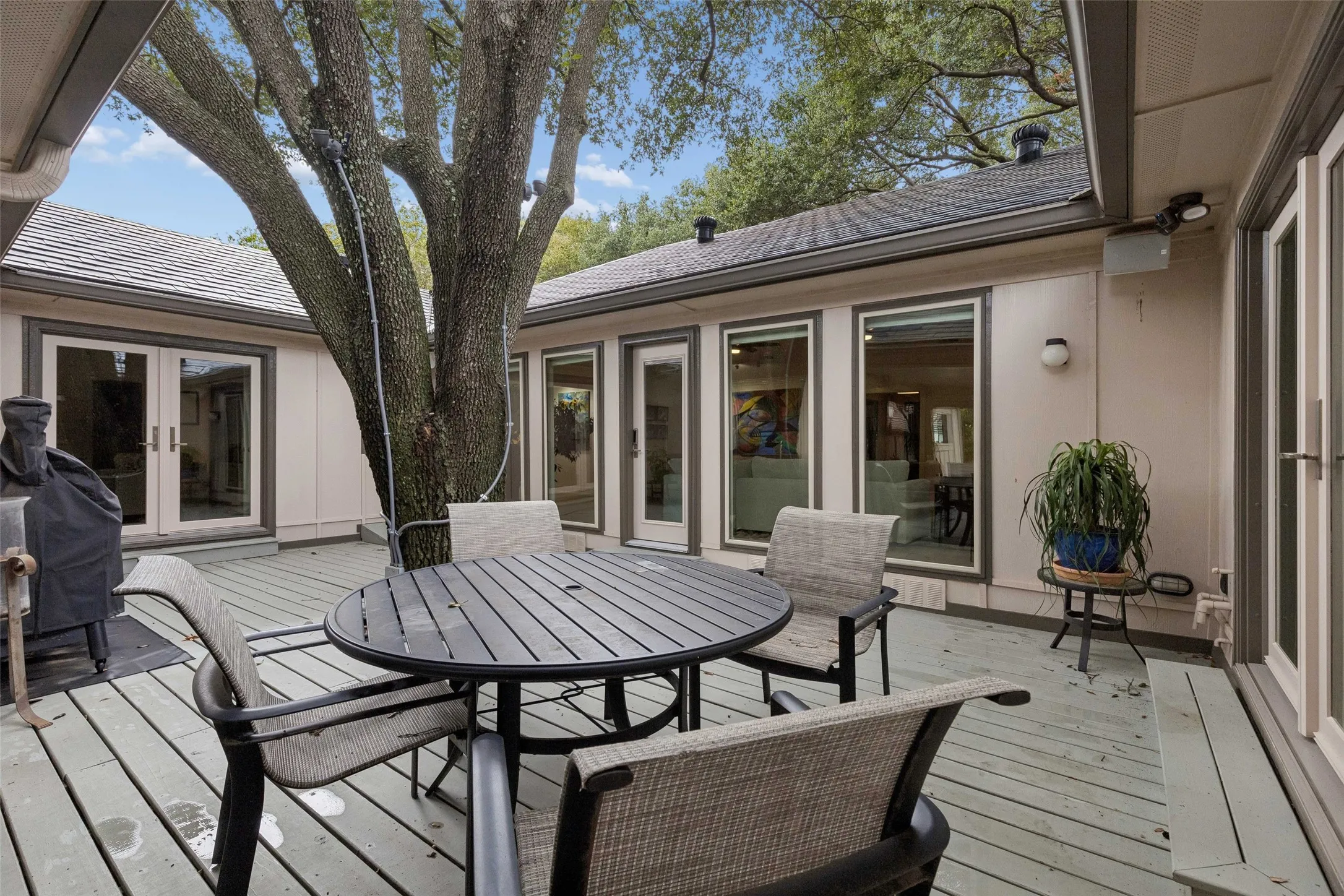 Indoor-Outdoor Connection on Display — Multiple windows and glass doors overlook the courtyard, bringing natural light inside while keeping the outdoor living area visually connected to the home.