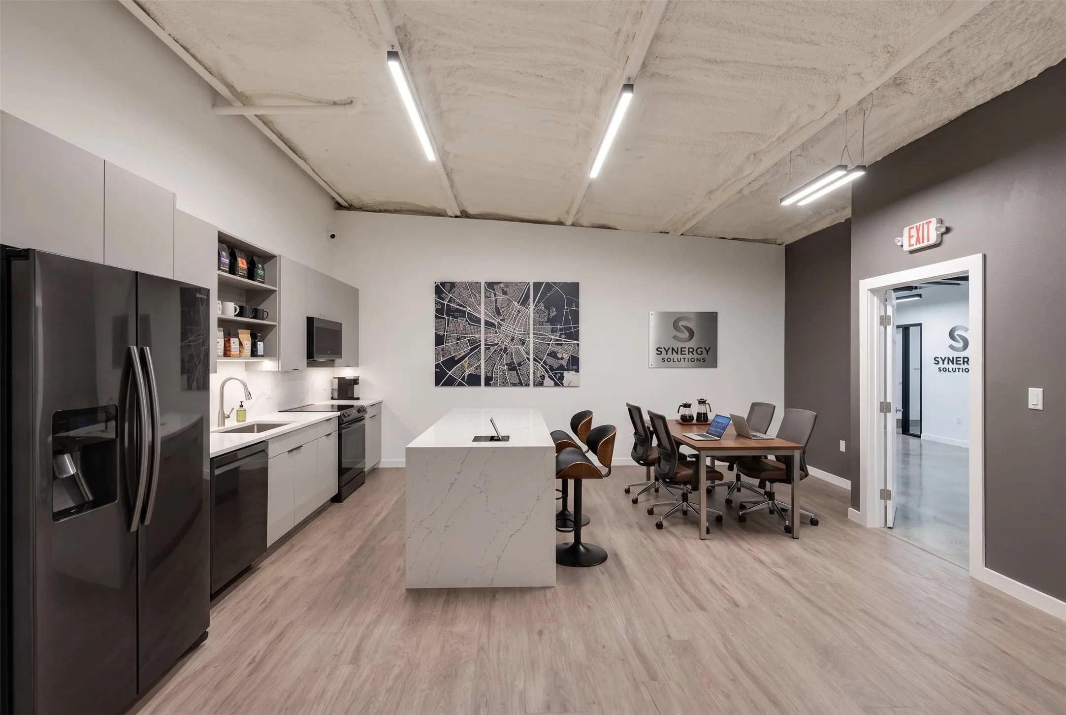 Open-concept space featuring wood-finish flooring, a kitchen area with gray cabinetry and black appliances, a white island, and a dining area