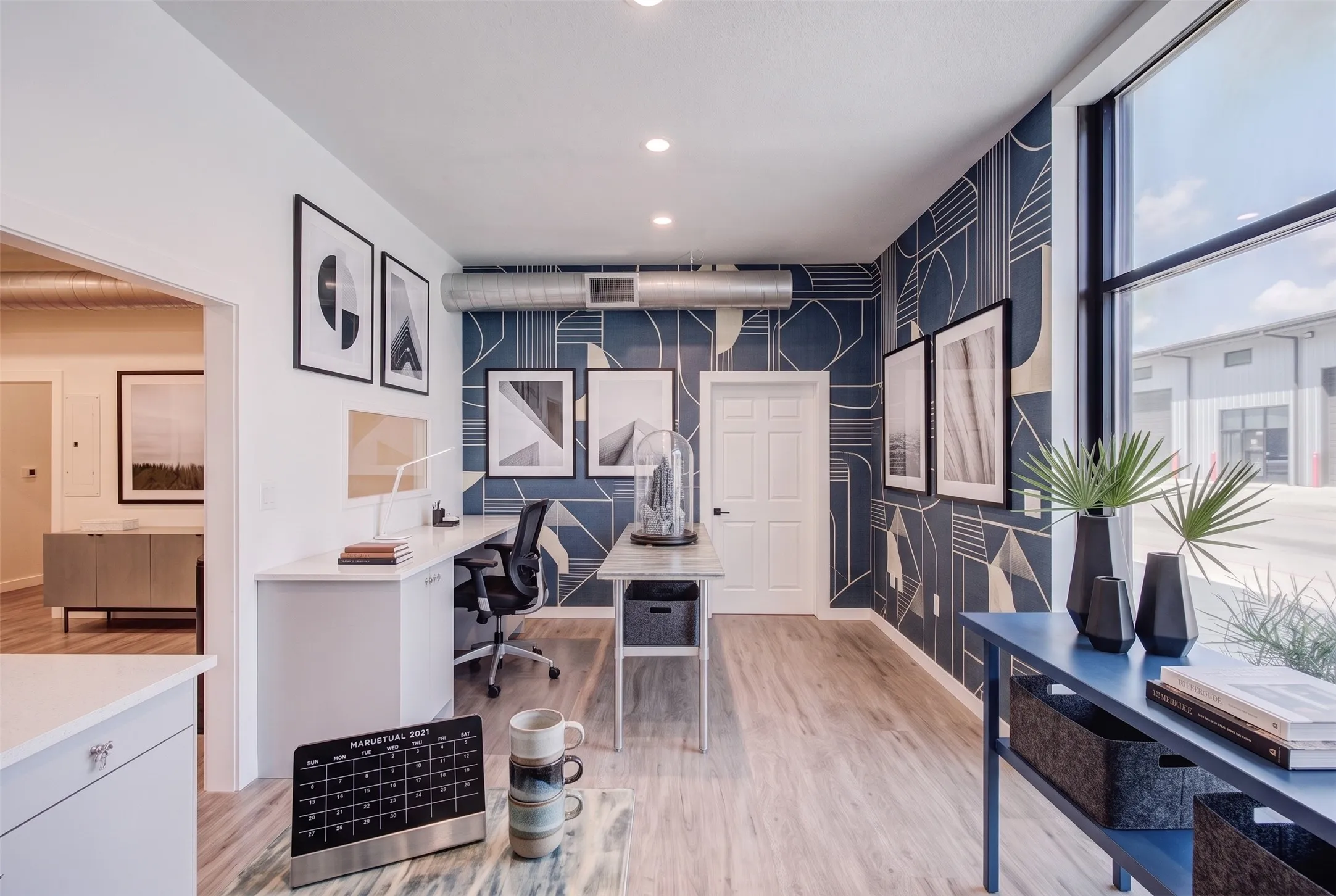 Recessed lighting and an exposed duct system complement a geometric accent wall - AI Generated