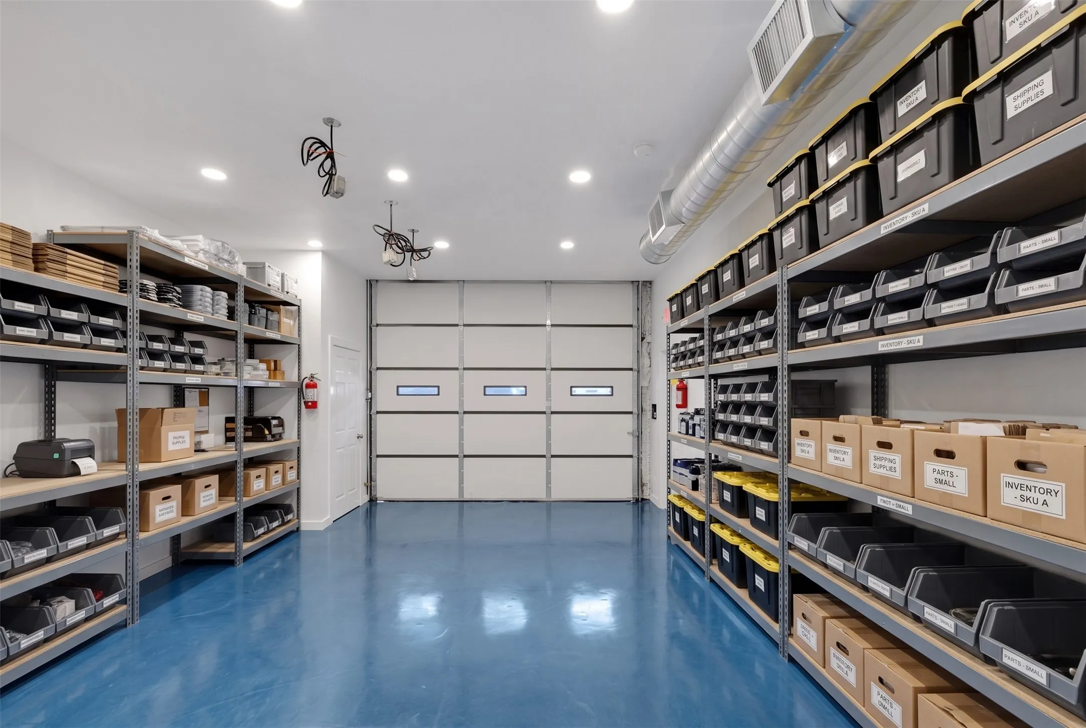 Industrial-style space featuring a roll-up garage door with windows, polished blue flooring, recessed ceiling lighting, and exposed ductwork - AI Generated
