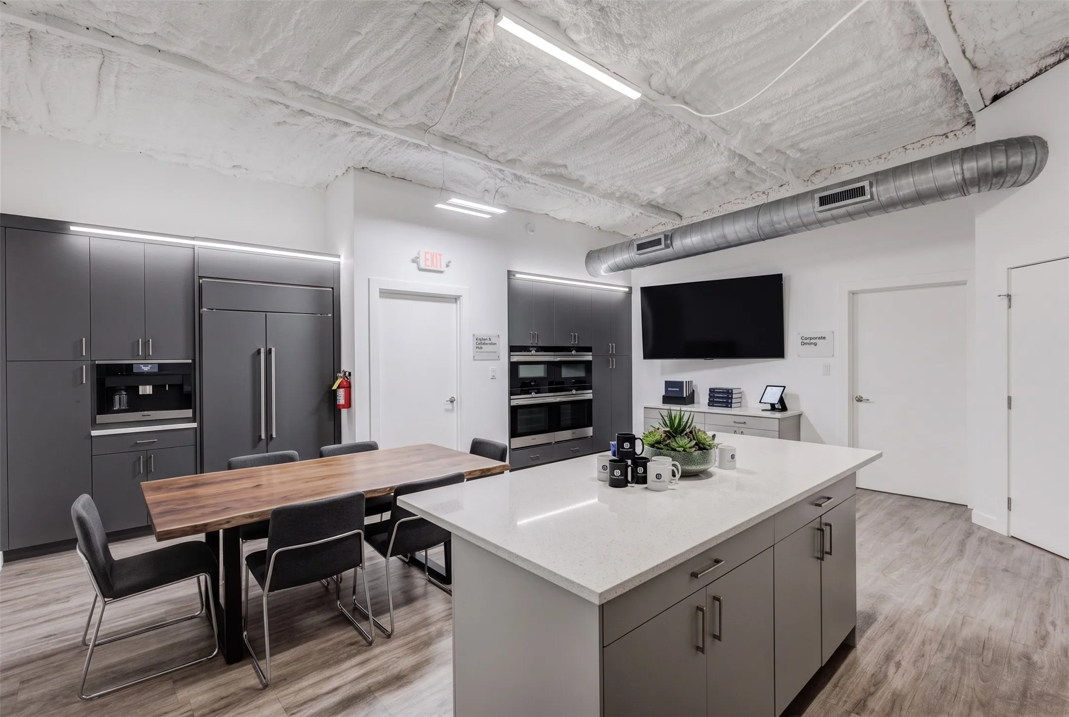 Kitchenette featuring a large center island with a light-toned countertop, built-in cabinetry, and wood-finish flooring